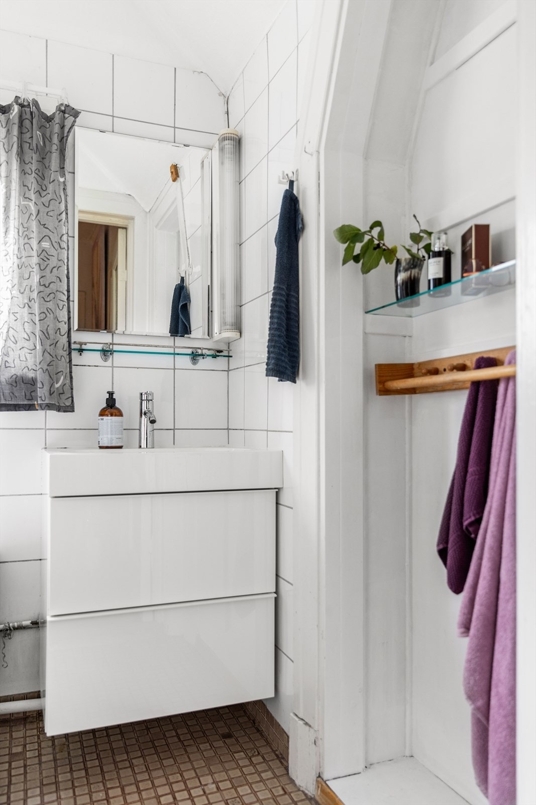 Badet er utstyrt med wc, servant med skuffer under og dusj i badekar. Det er flislagt gulv med varmekabler. Galleribilde