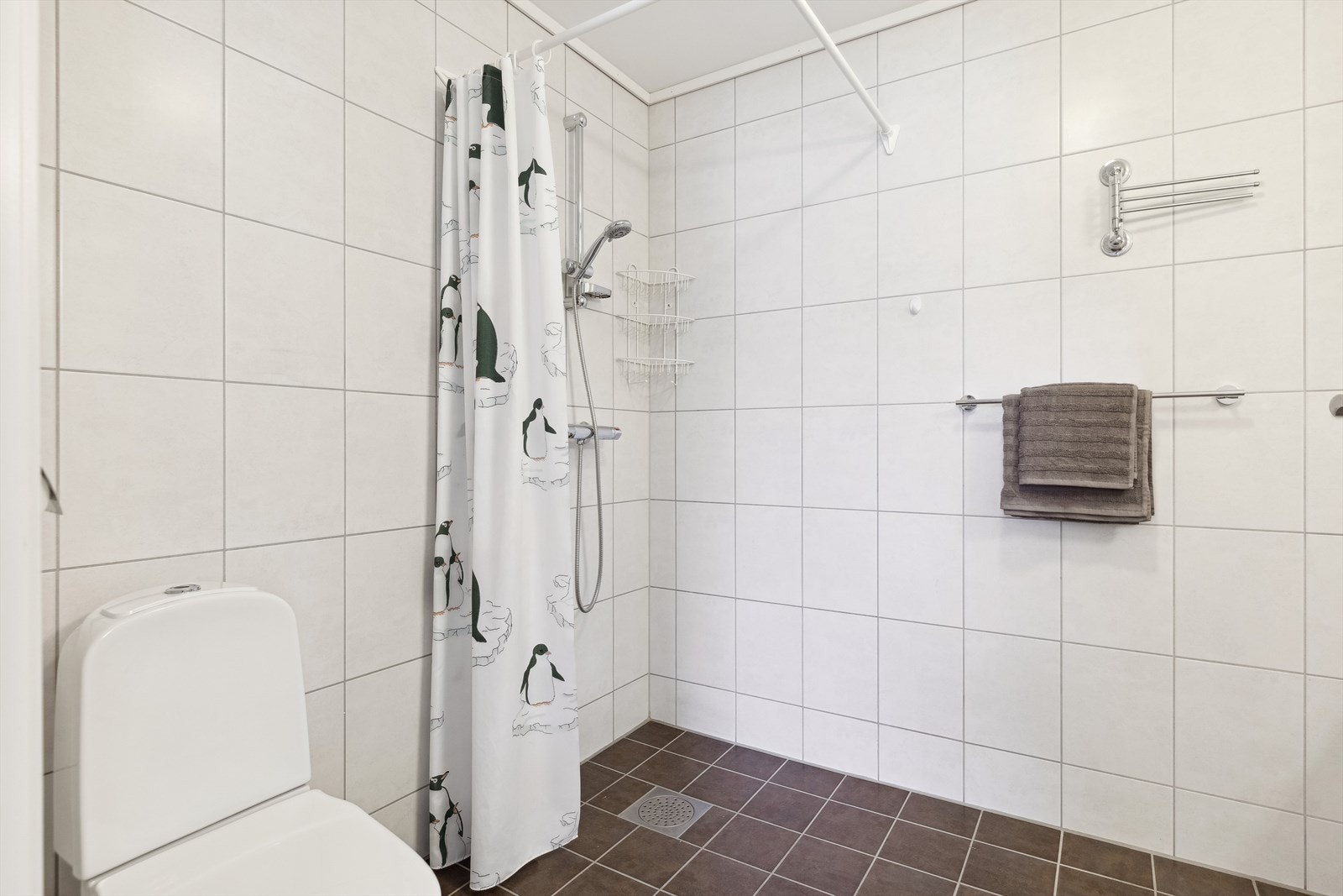 Badet er utstyrt med baderomsinnredning, opplegg for vaskemaskin, toalett og dusjhjørne. Galleribilde