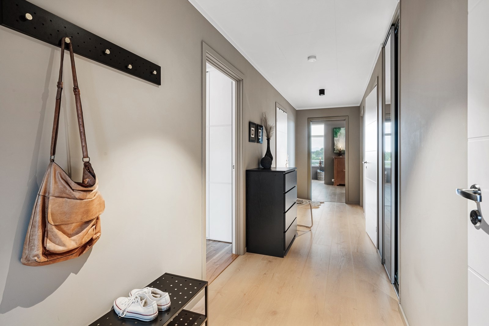 Du kommer inn til en lys entré med skyvedørsgarderobe. Galleribilde