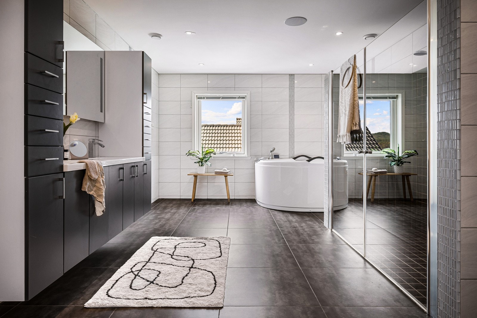 Helfliset hovedbad på hele 19,4 kvm med store eksklusive fliser og lekker baderomsinnredning. Galleribilde