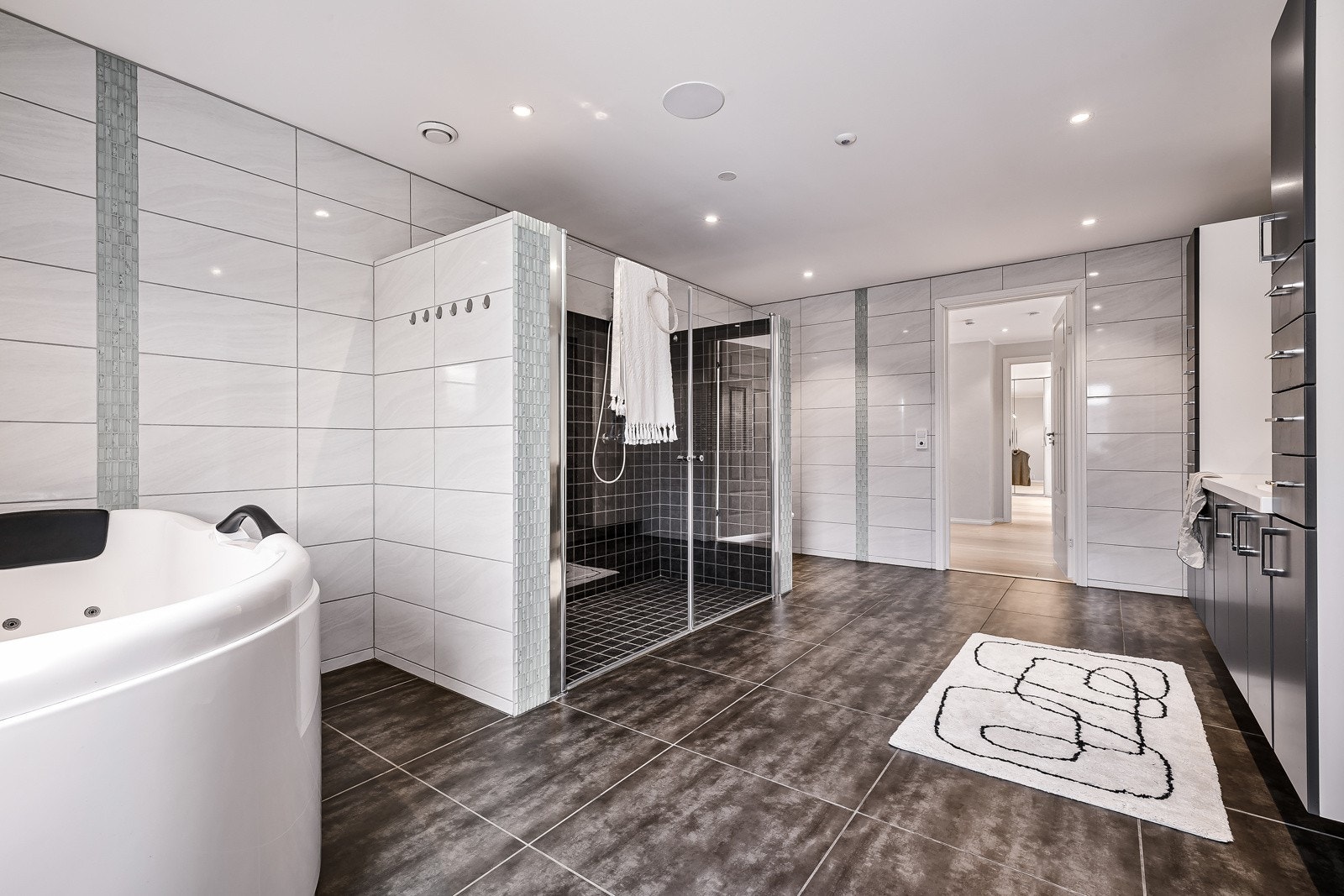 Badet har alt du trenger og er innredet med badekar, dobbel servant med møblement, vegghengt toalett og dusjnisje med dobbel dusj. Galleribilde