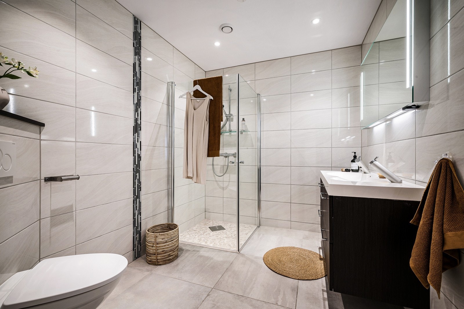 Badet i 1. etasje er helfliset og innredet med dusjvegg, møblement og vegghengt toalett. Galleribilde