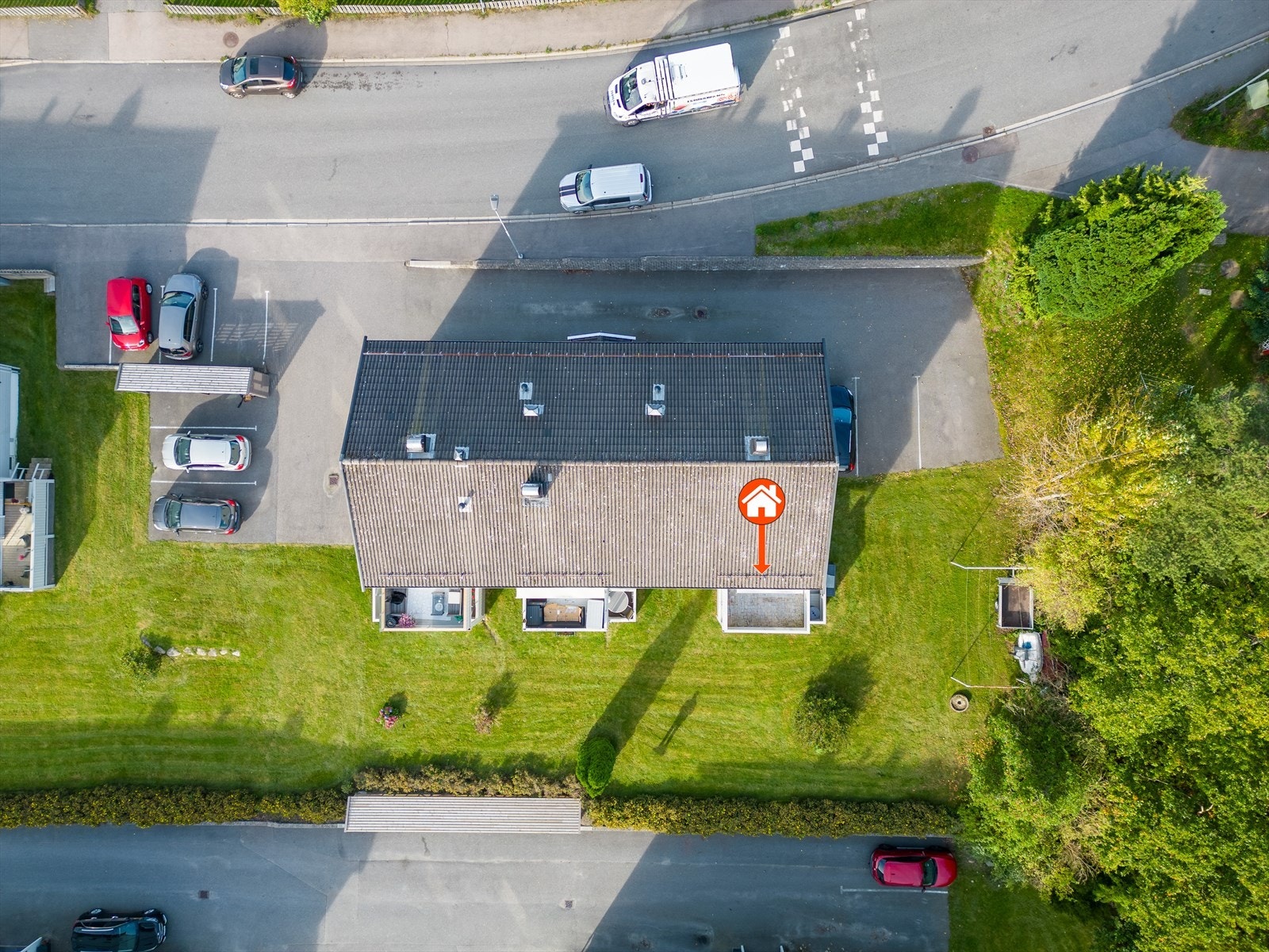 Dronebildet viser området med parkering og plen Galleribilde