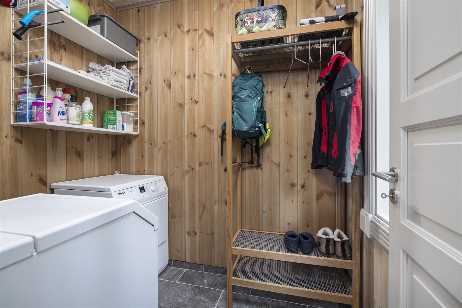 Praktisk vaskerom med opplegg for vaskemaskin og plass til oppbevaring. Galleribilde