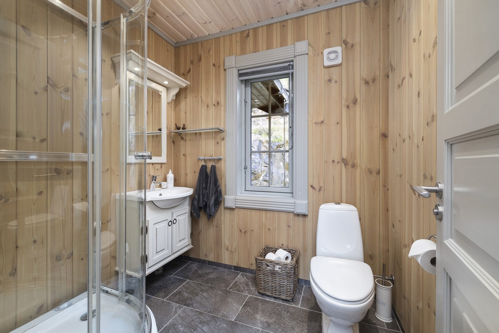 Hytta har 2 bad som begge har fliser på gulv og panel på vegger og i tak. Galleribilde