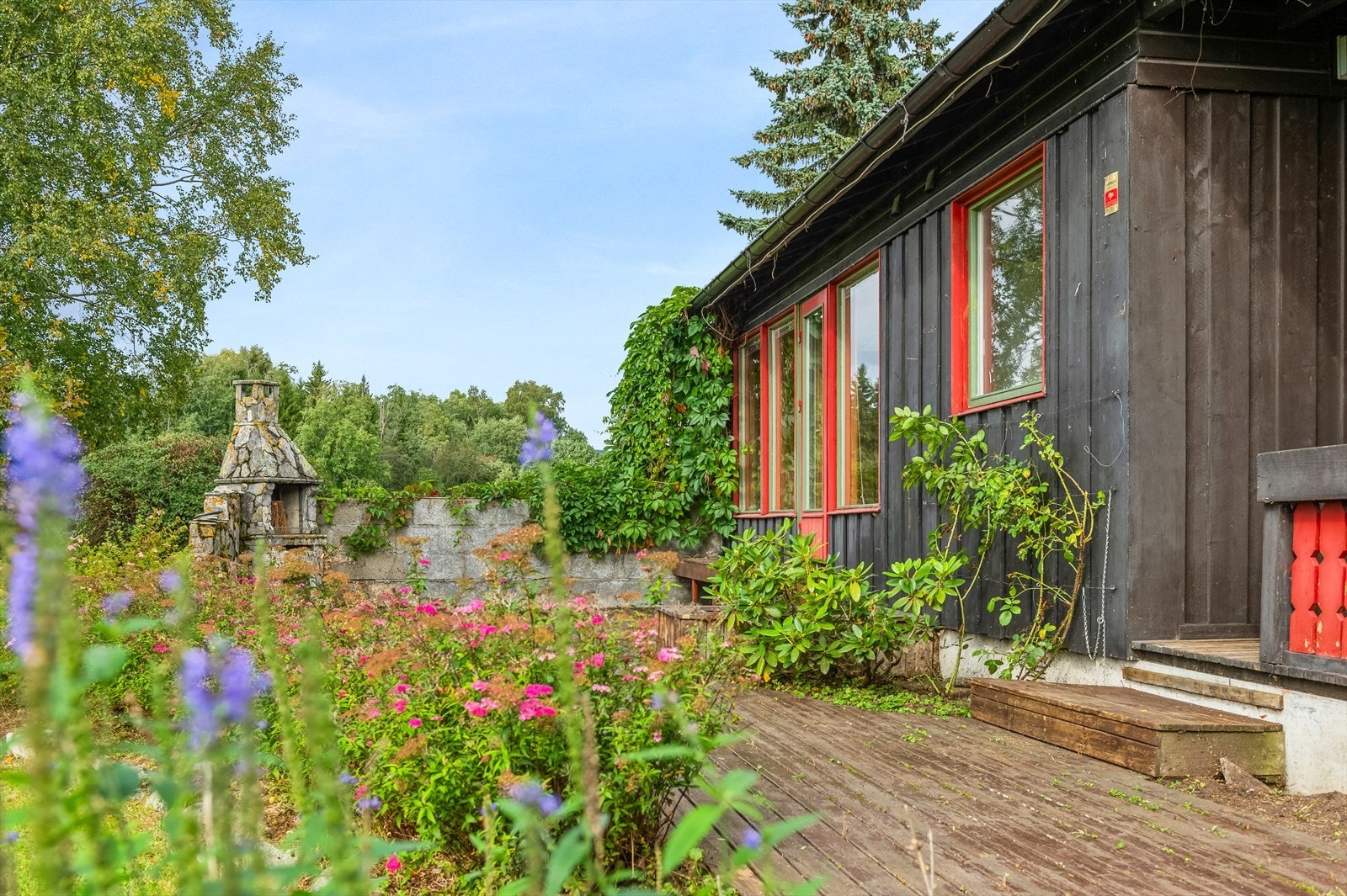 Fra terrassen kommer man rett ut til den hagen. Hagen er opparbeidet med plen og beplantning. Galleribilde