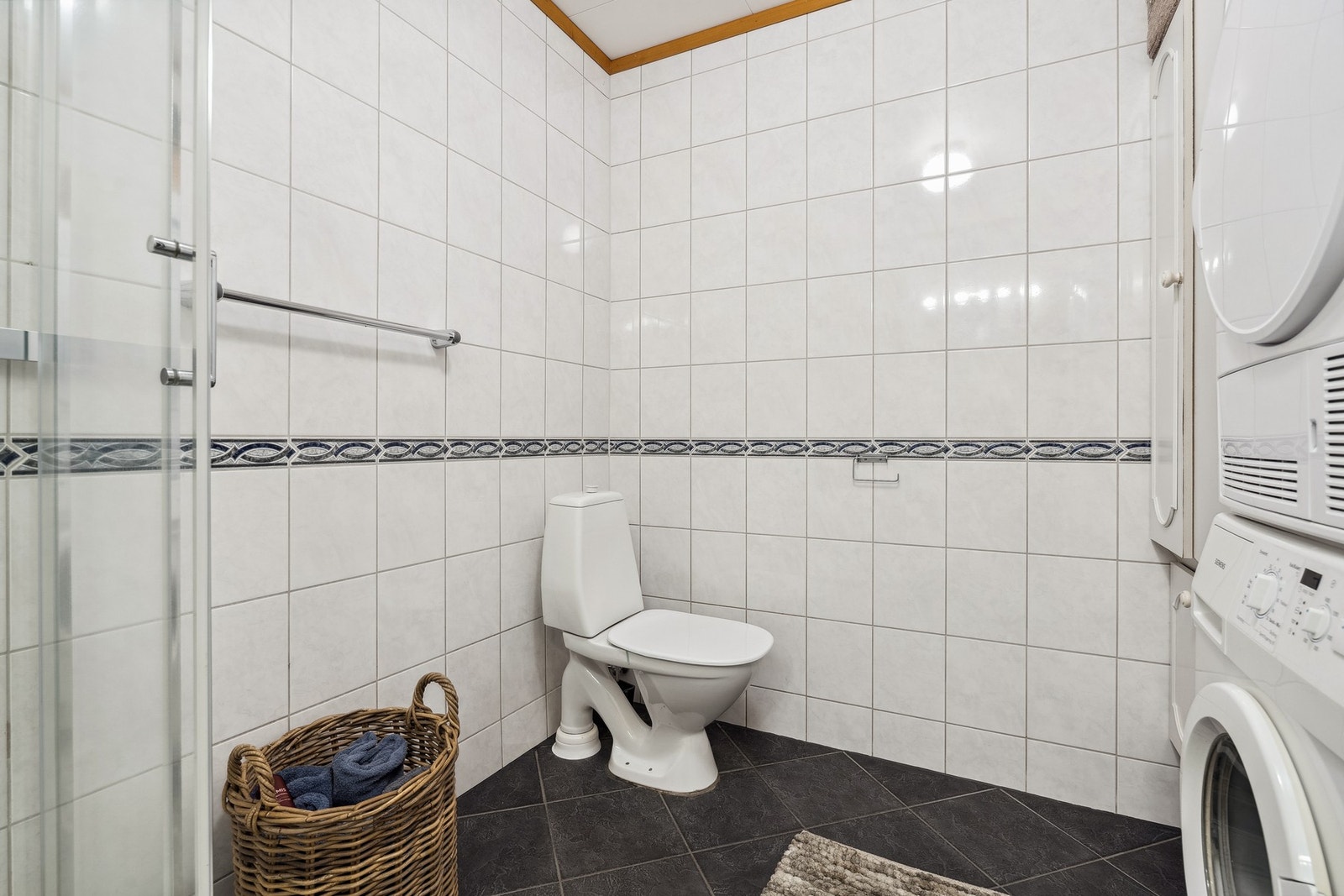 Rommet har innredning med nedfelt servant, toalett, dusjkabinett og opplegg for vaskemaskin. Galleribilde