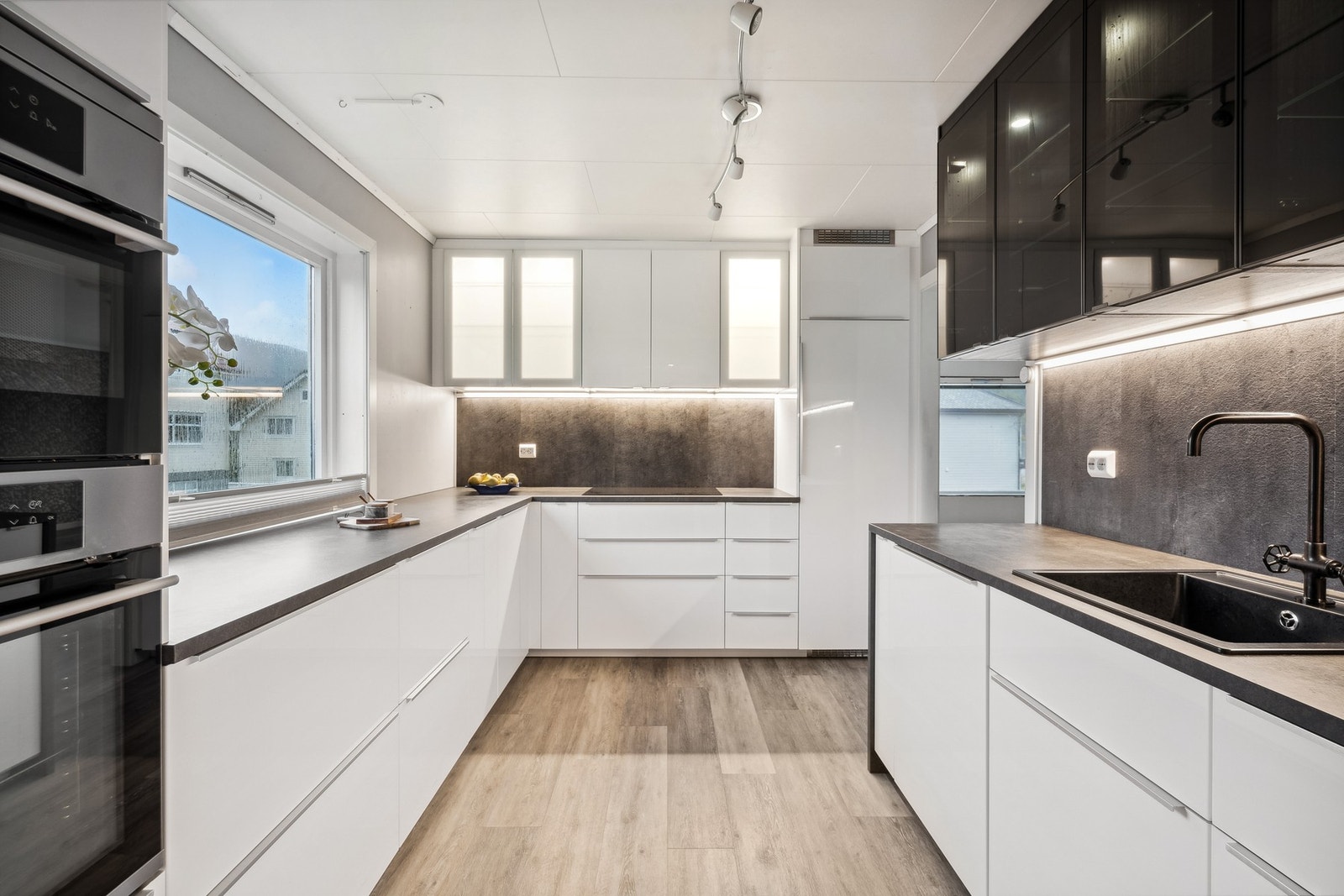 Flott kjøkken med innredning med glatte fronter. Benkeplaten er av laminat. Galleribilde