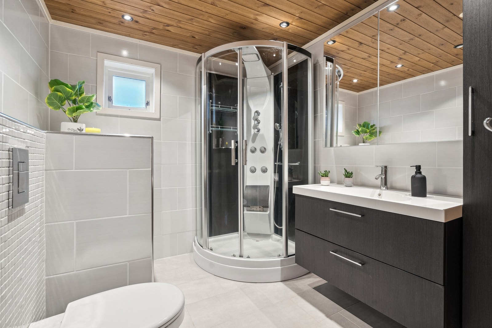 Rommet har innredning med nedfelt servant, veggmontert toalett og dusjkabinett. Galleribilde