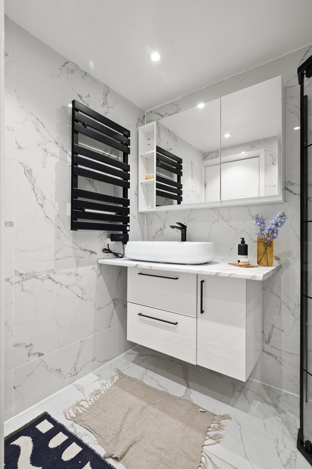 Baderomsinnredningen består av servant på benkeplate med underskap og speilskap Galleribilde