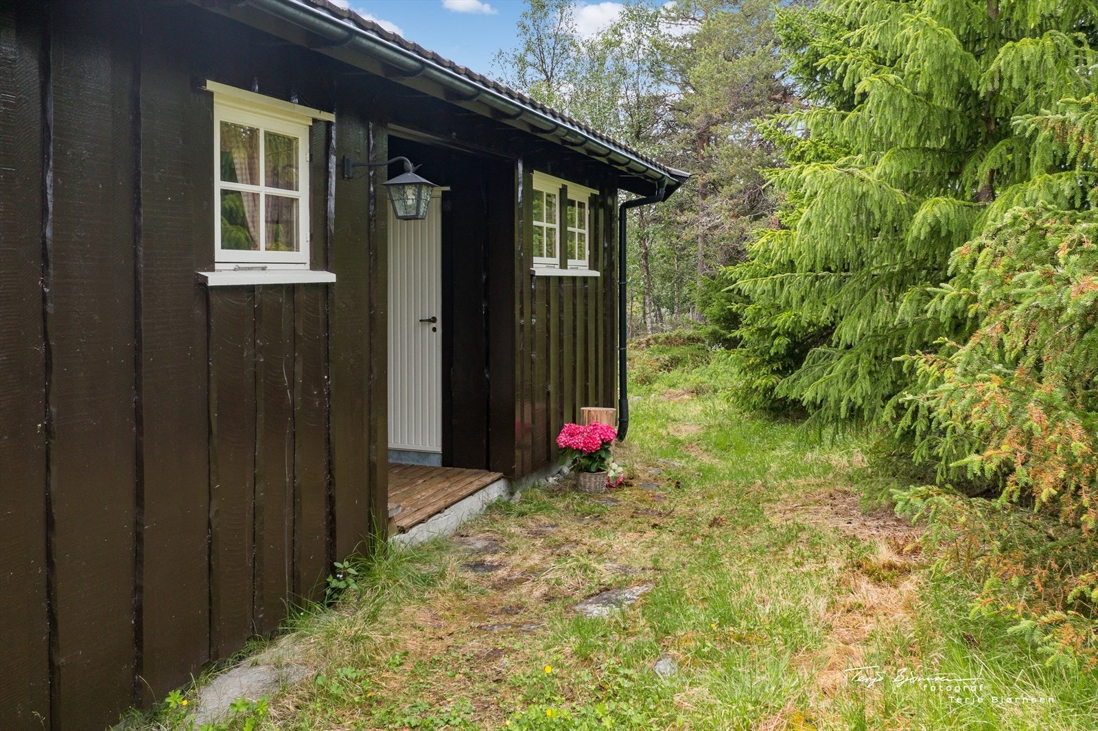 Hytta har et overbygget inngangsparti så en kan gå tørrskodd inn i boden. Galleribilde