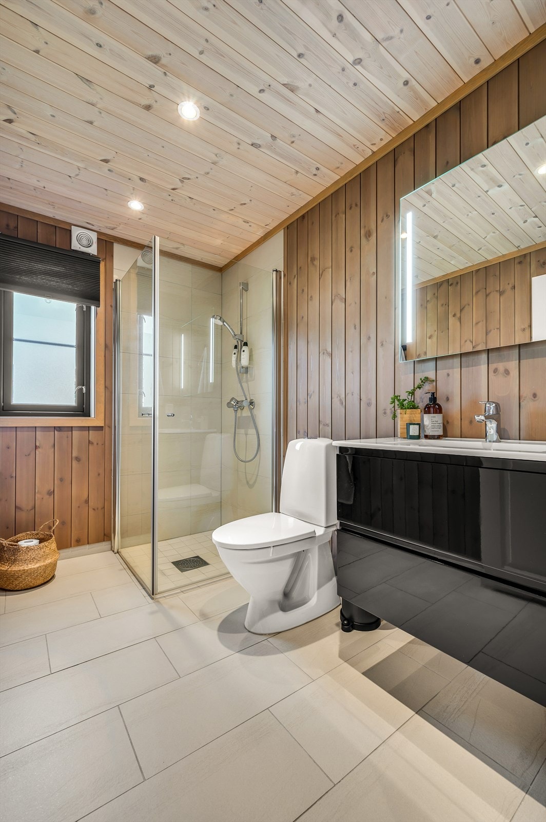 Badet er utstyrt med dusjhjørne, toalett og servantinnredning. Galleribilde