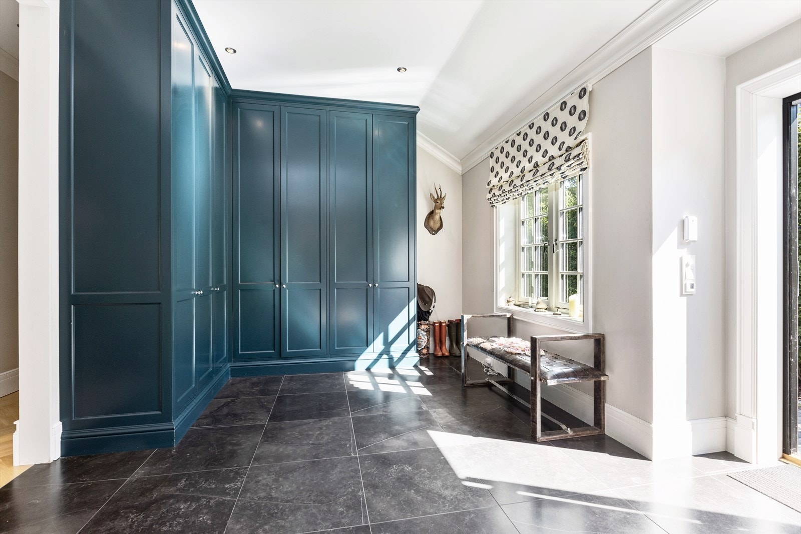 Innbydende entré med snekkerbygde garderobeskap med rikelig av plass til oppbevaring. Galleribilde