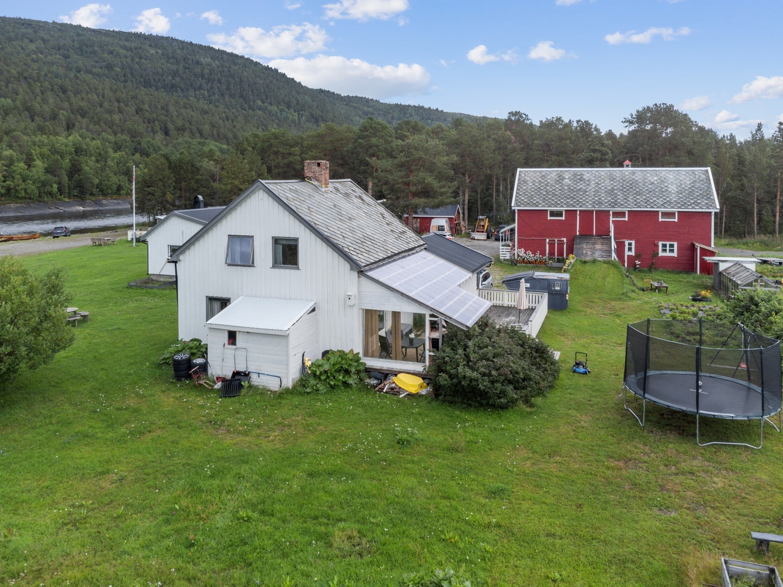 Oversikt over gårdstunet med de ulike bygningene og et stort, grønt uteområde. Galleribilde