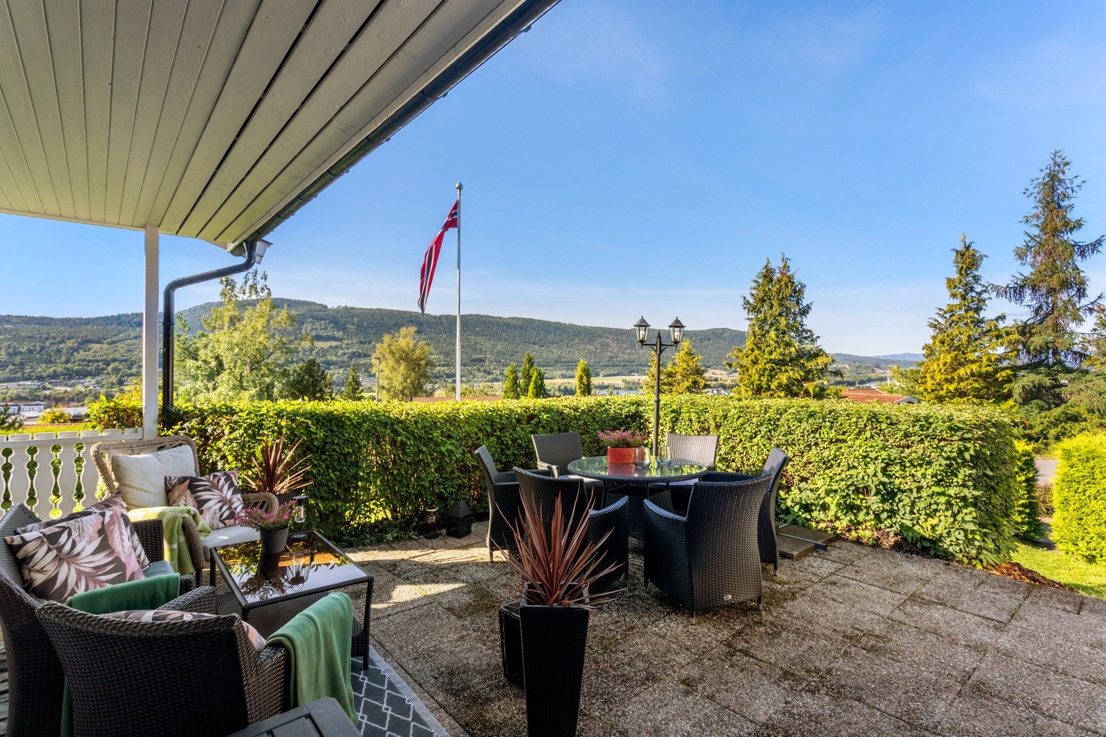 Delvis overbygget sørvestvendt hellelagt terrasse Galleribilde
