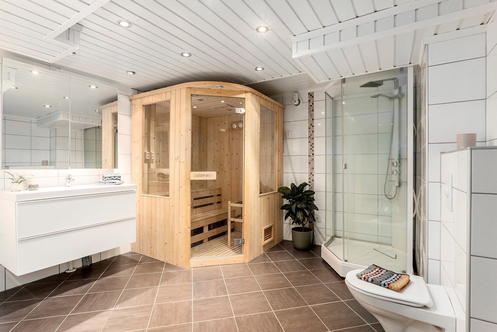 Stort bad/wc med hjørnebadekar og dusjnisje samt frittstående badstue - vannbåren gulvvarme (jordvarme) Galleribilde