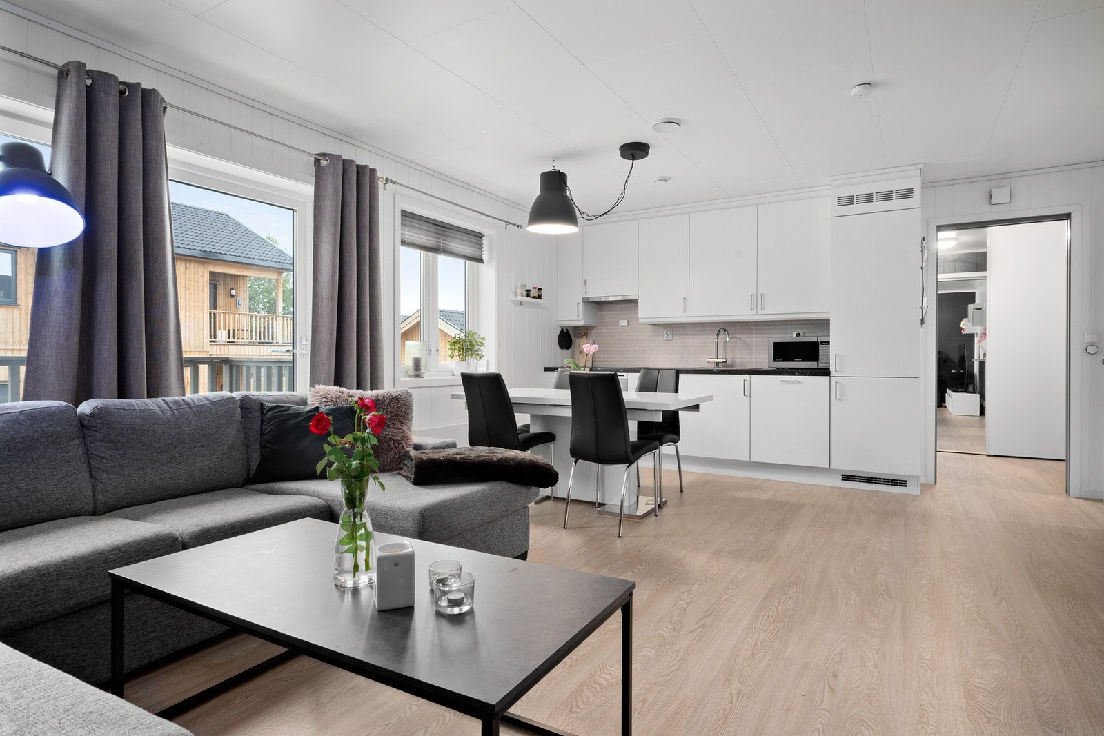Her får du en åpen stue- og kjøkkenløsning med god plass til sofa og spisebord Galleribilde