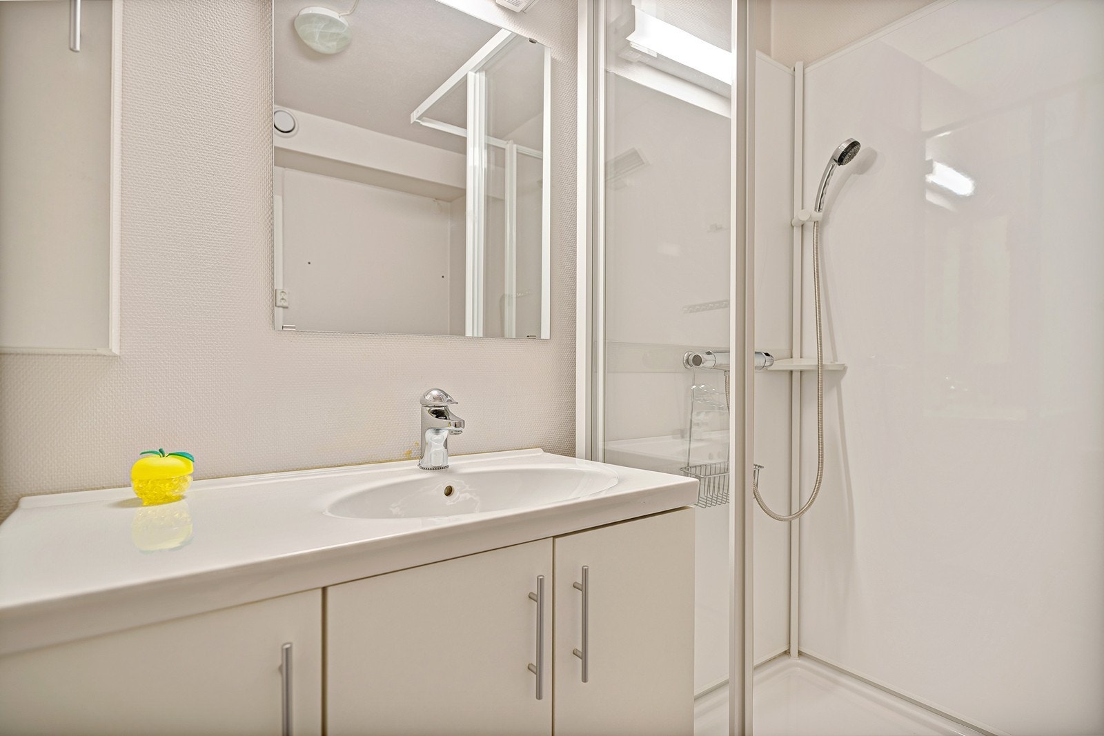 Badet er innredet med dusjkabinett, heldekkende servant i baderomsinnredning og opplegg til vaskemaskin Galleribilde