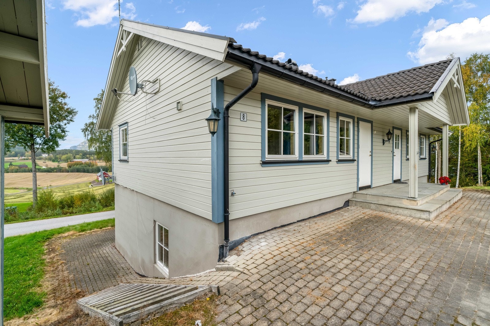 Stor tomt med gruset innkjørsel, belegningsstein, steinsatte murer/trapper og plen. Platting ved inngangsparti, samt egen uteplass for hver av leilighetene. Galleribilde