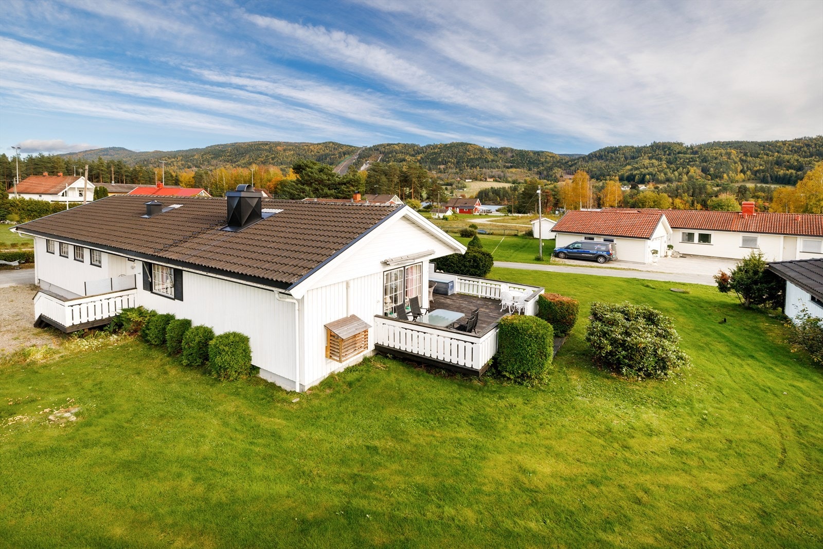 Eiendommen har en relativt flat tomt som er opparbeidet med gress og diverse beplantning. Galleribilde