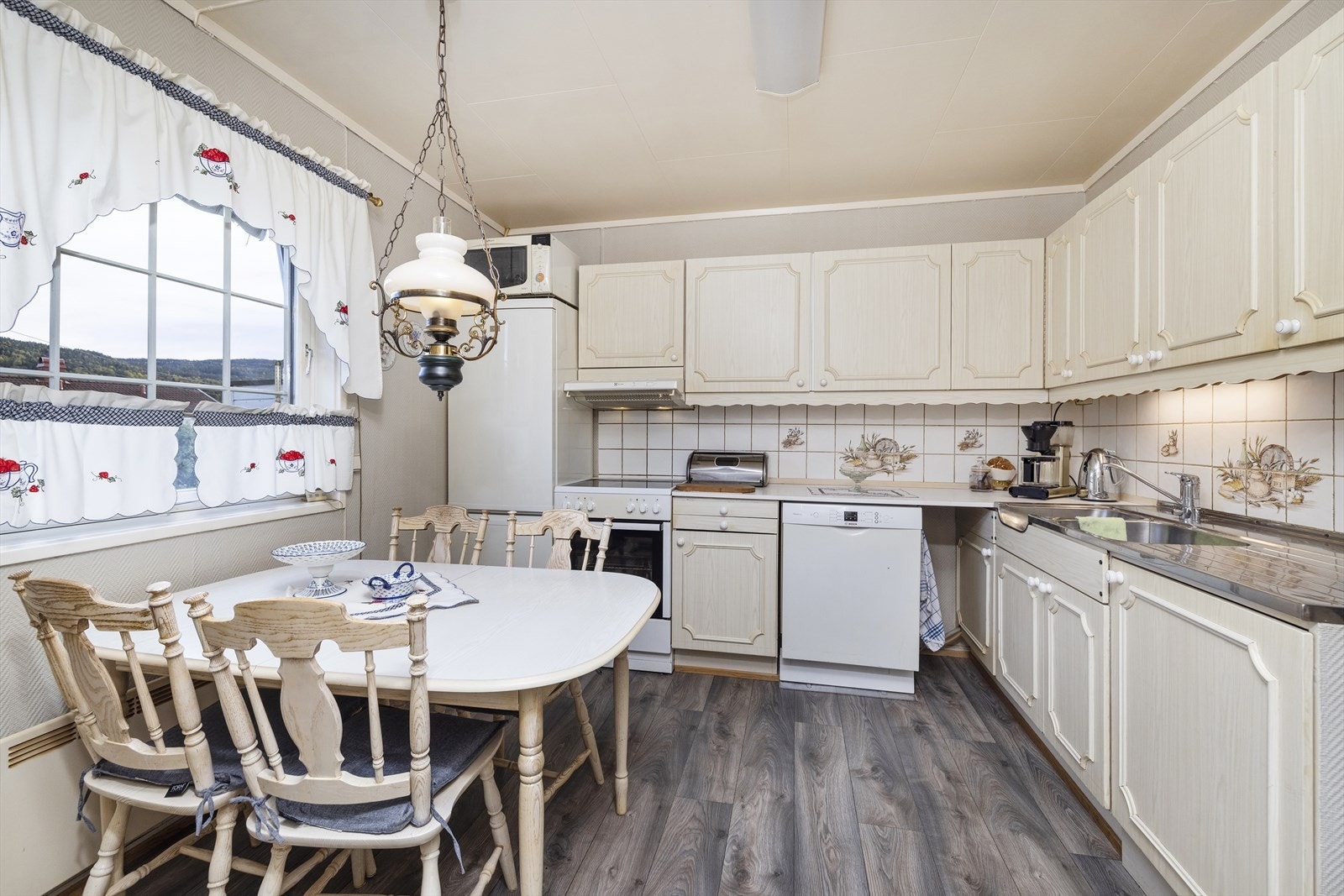 Kjøkken med profilerte fronter og benkeplate i laminat og stålbenk med vask. Galleribilde