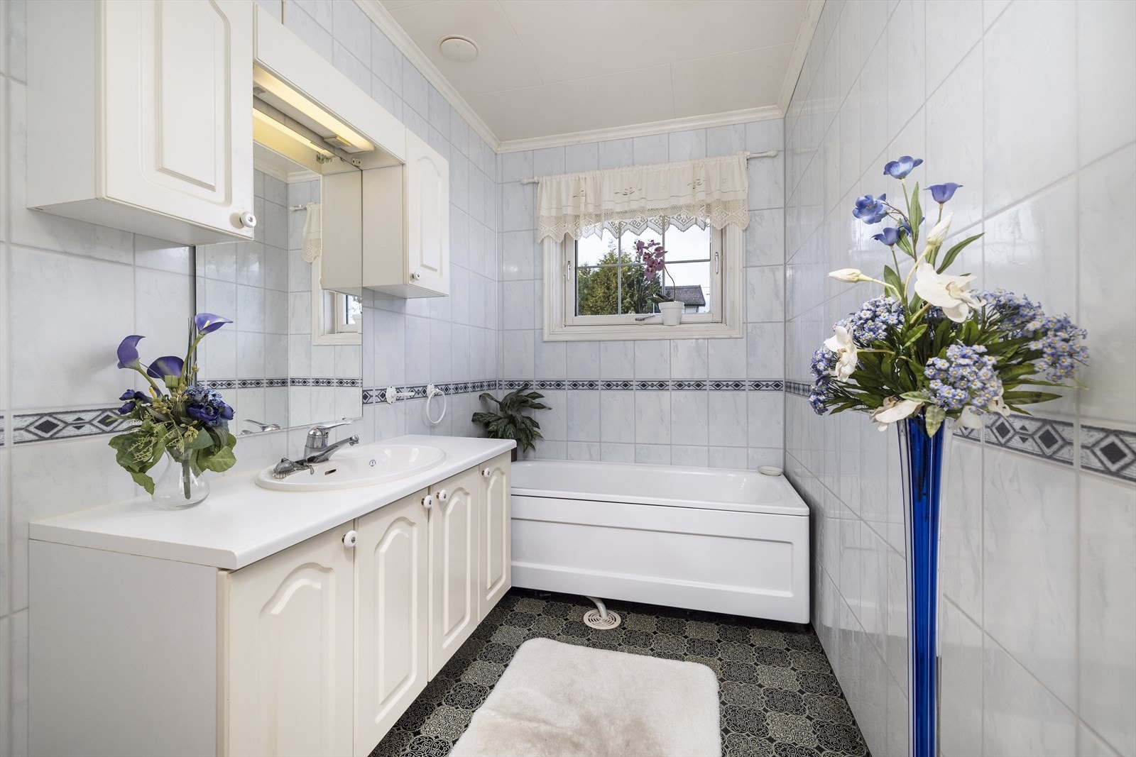 Badet er innredet med servant med god oppbevaring og badekar. Galleribilde