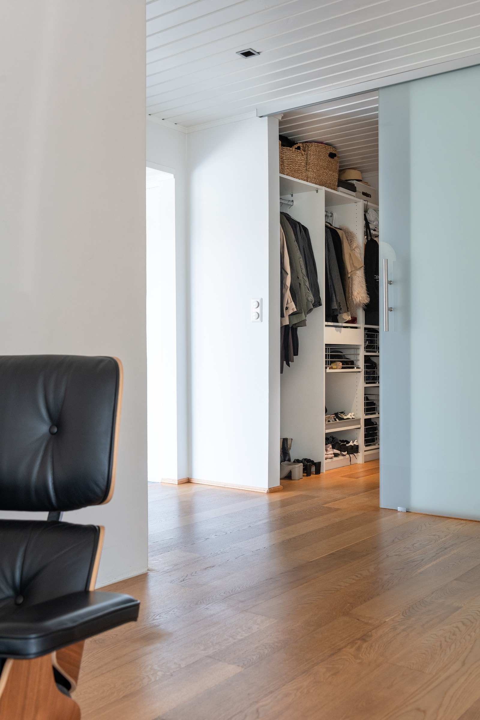 En elegant garderobe bak skyvedør av frostet glass. Galleribilde