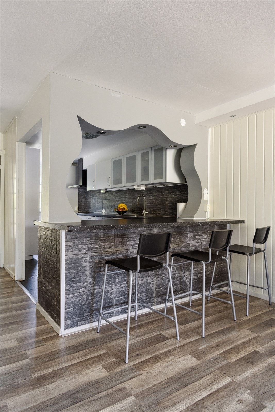 Det er bygget en hyggelig frokostbar-løsning med åpning inn til kjøkkenet. Galleribilde