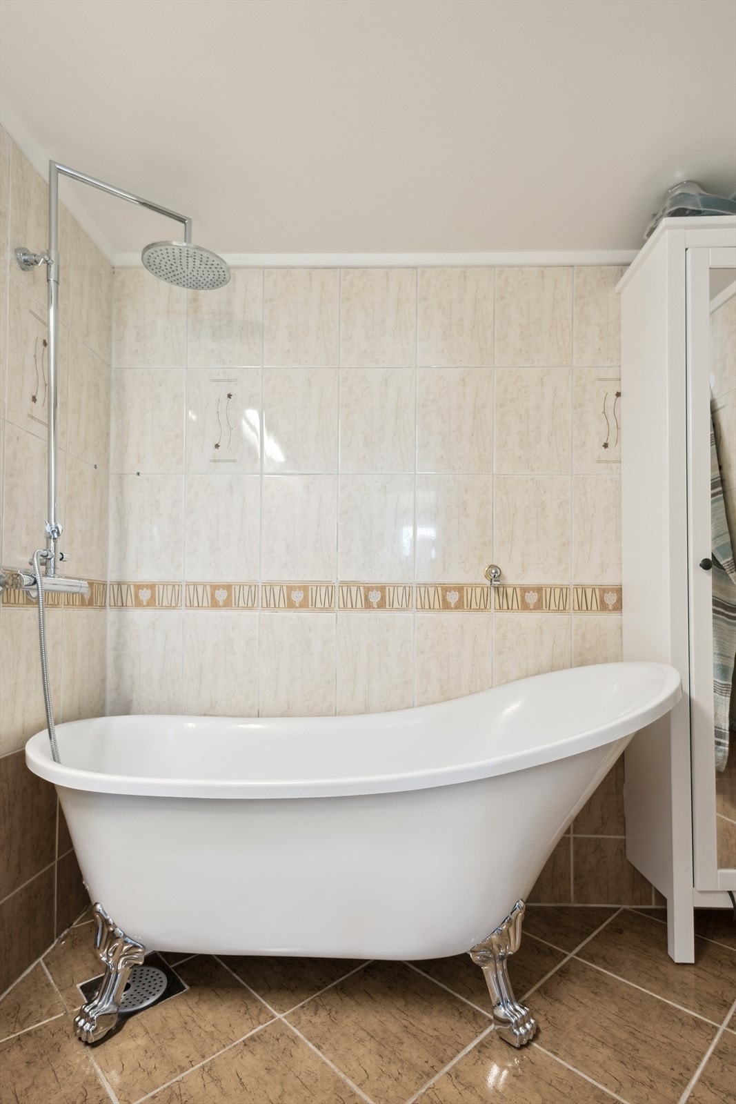 Dette badet er utstyrt med badekar, dobbelt servantinnredning med skuffer og overskap, samt opplegg og plass til vaskemaskin. Galleribilde