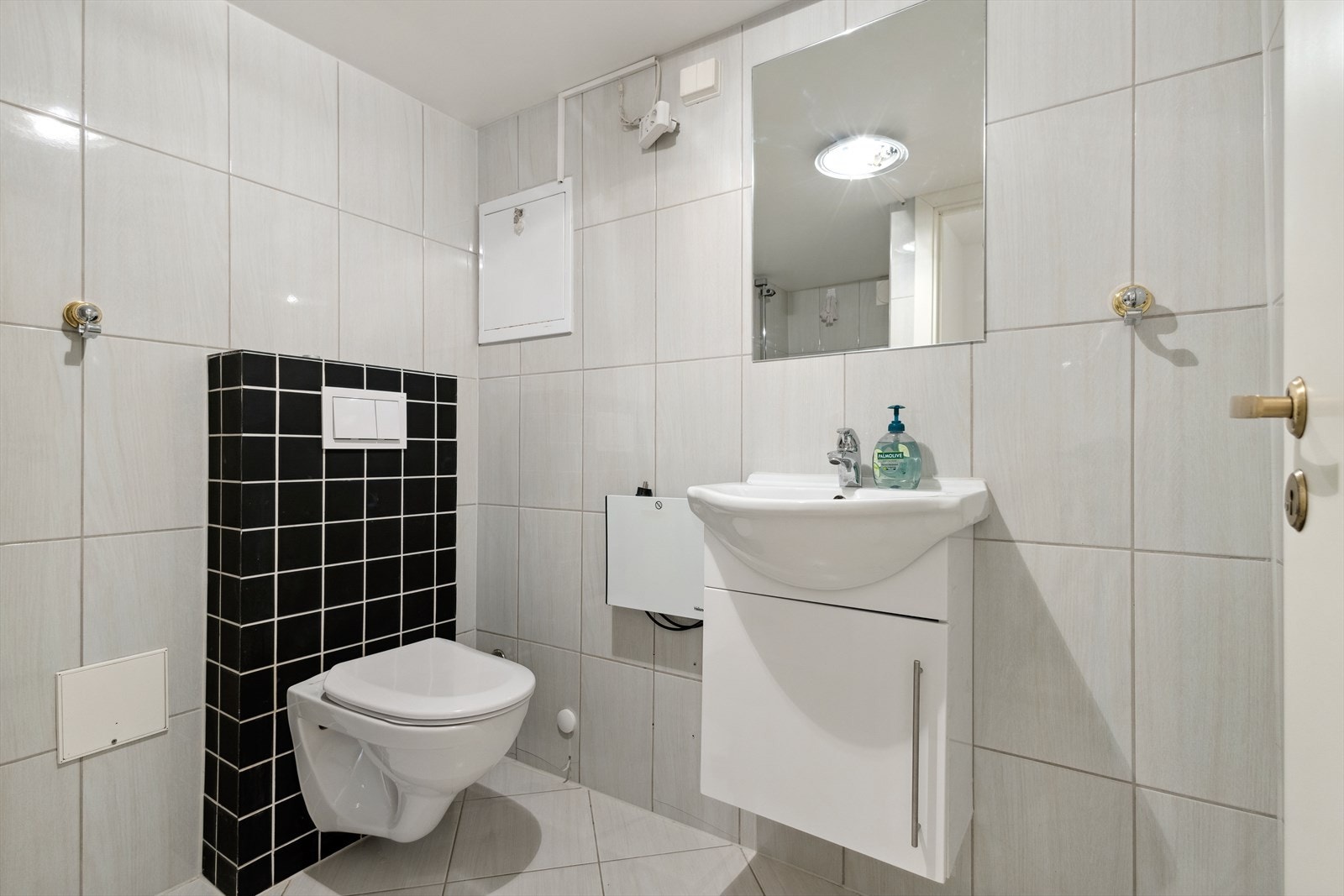 Pent flislagt bad utstyrt med vegghengt wc og servantinnredning med underskap. Galleribilde