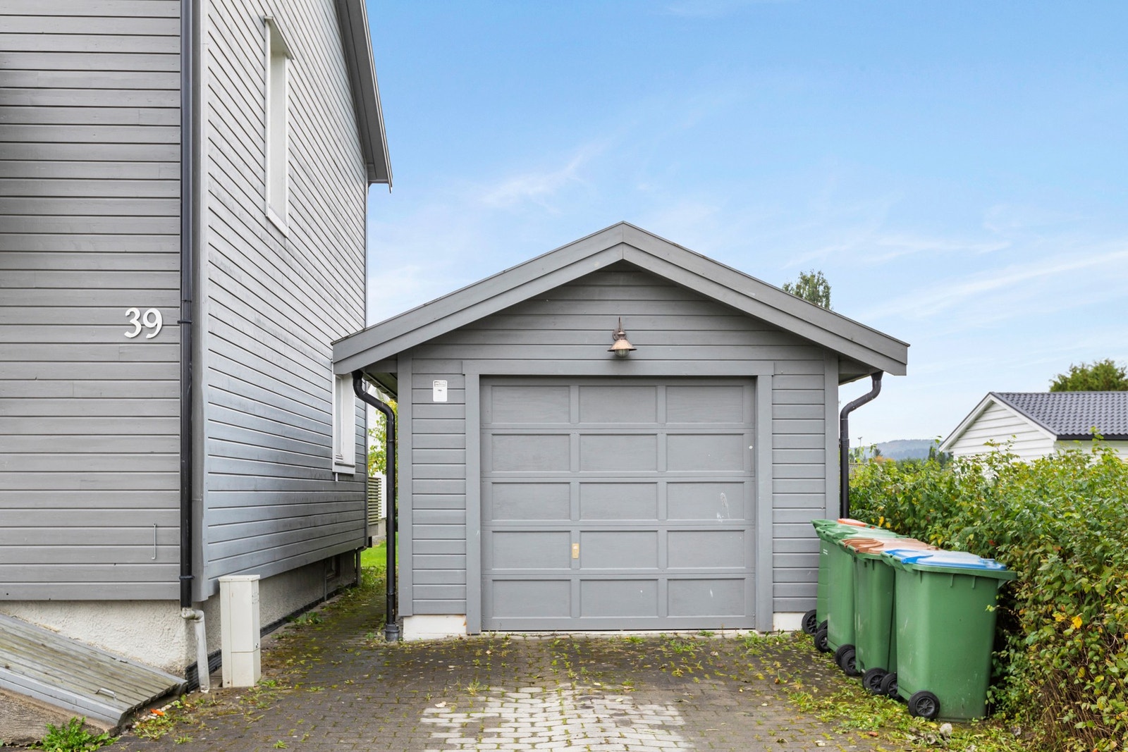 Garasje med leddport i tre og mekanisk portåpner. Galleribilde