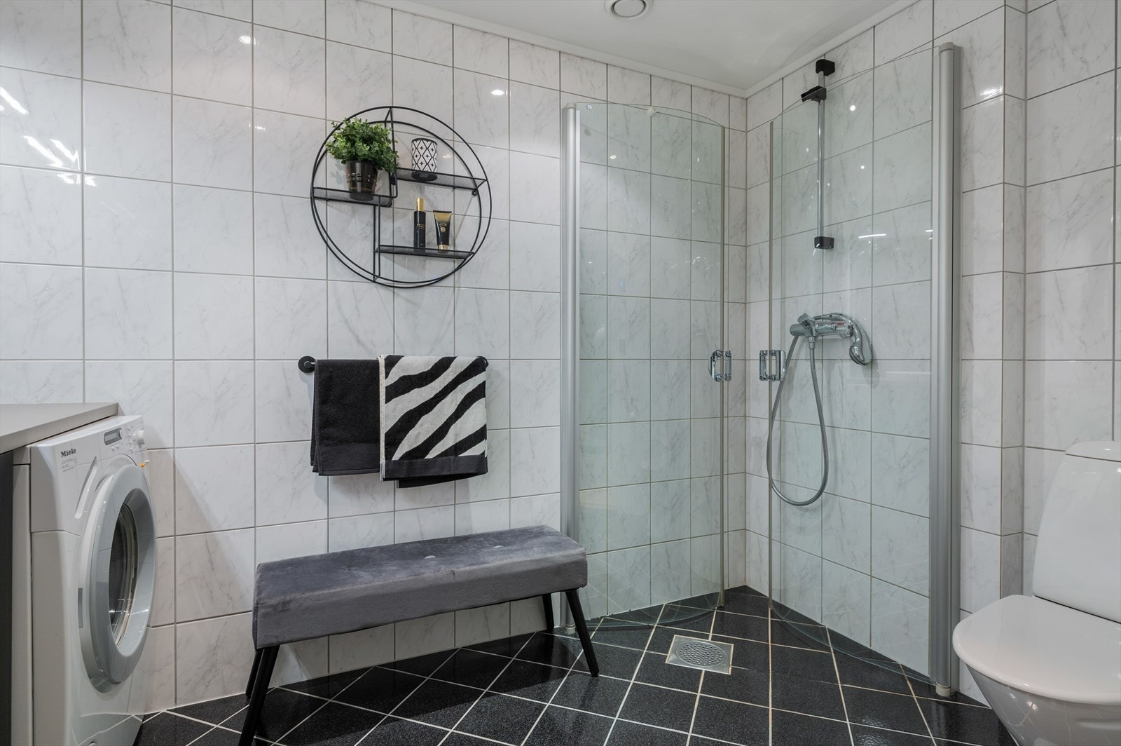 Badet er utstyrt med stort dusjhjørne, toalett og baderomsinnredning. Galleribilde