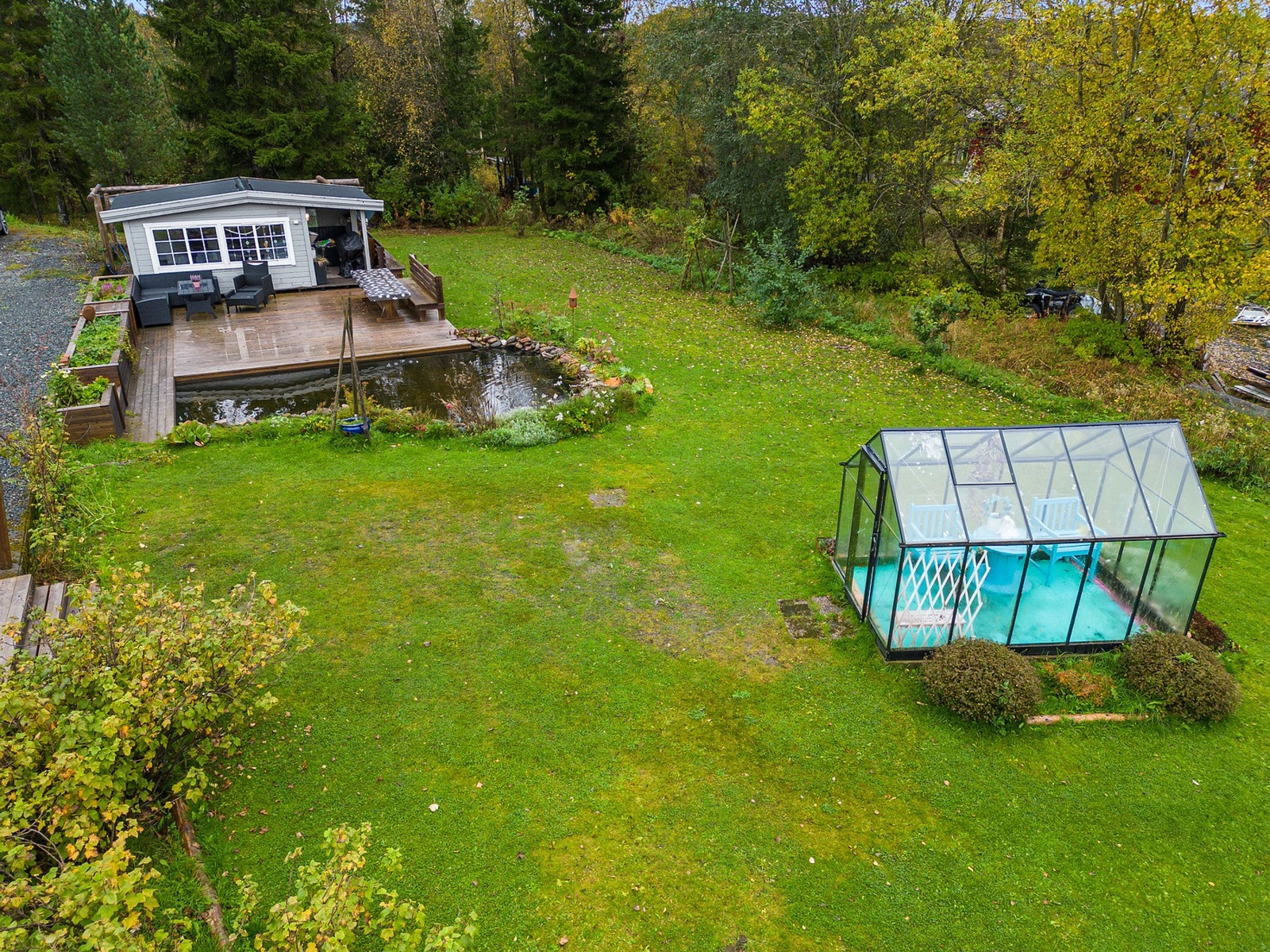 Pent opparbeidet hage med hagedam, hagestue og drivhus. Galleribilde