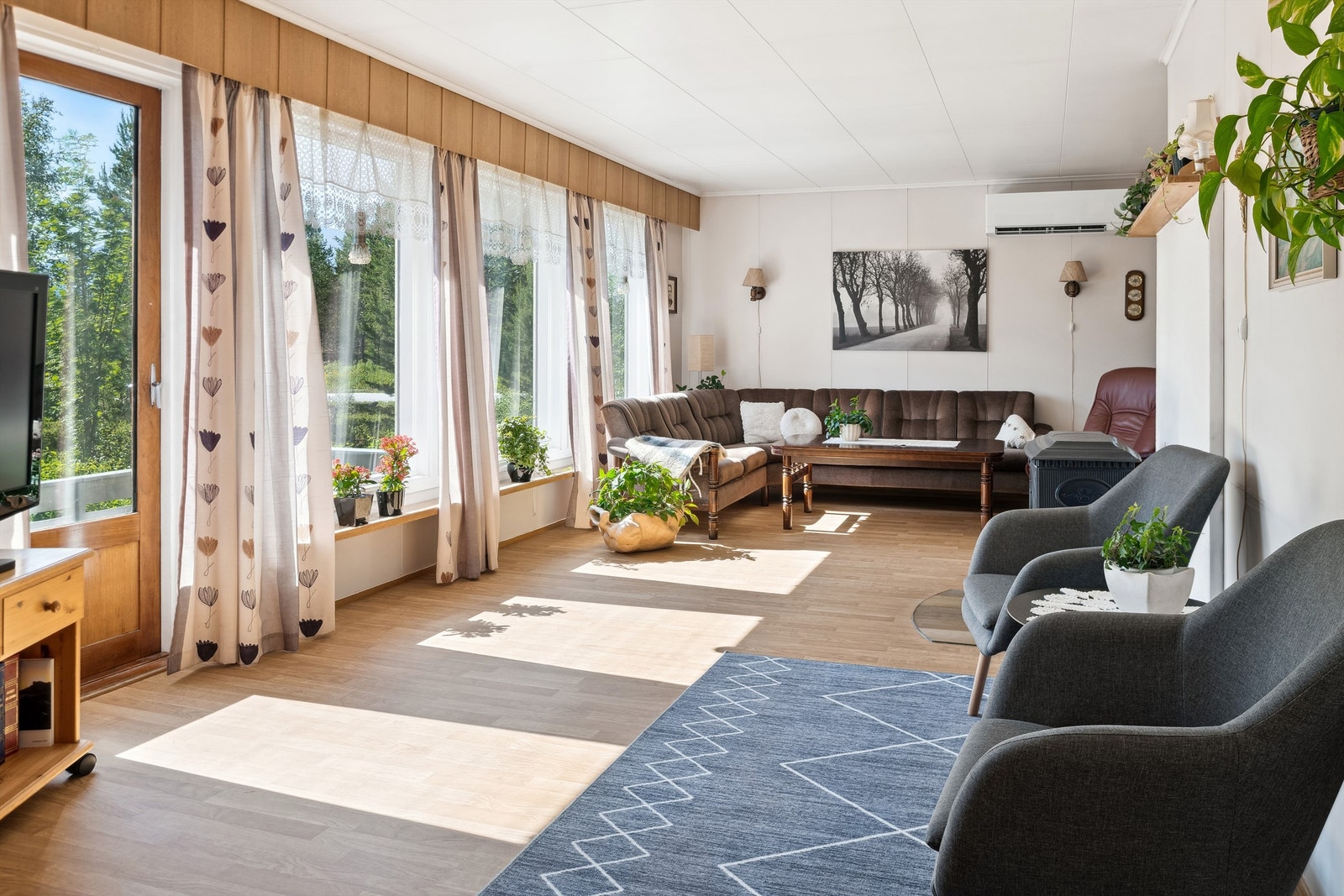 Lys og pen stue med store vinduer og utgang til terrassen Galleribilde