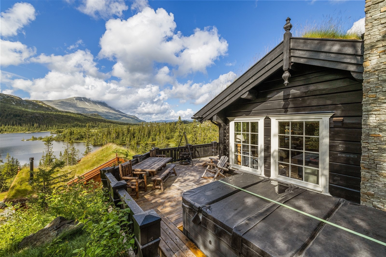 Stor romslig terrasse rundt fritidsboligen og er på ca. 60 m² med jacuzzi. Her er det både flotte solforhold og flott utsikt. Jacuzzi, bålpanne og alle utemøbler følger fritidsboligen. Galleribilde