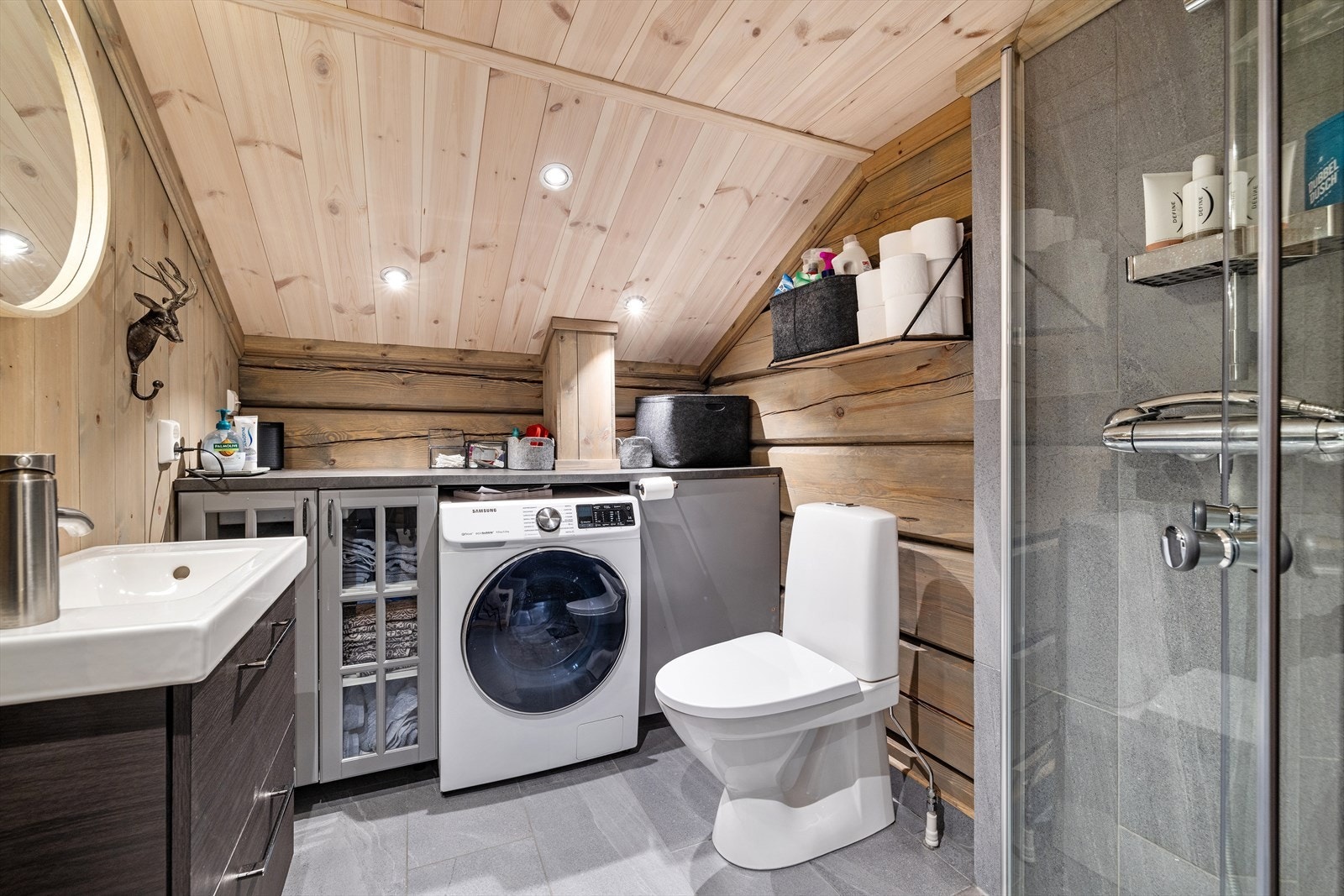 Badet er innredet med nedfelt servant, toalett, dusjhjørne i glass og opplegg for vaskemaskin. Her følger kombinert vaskemaskin/tørketrommel med salget. Galleribilde
