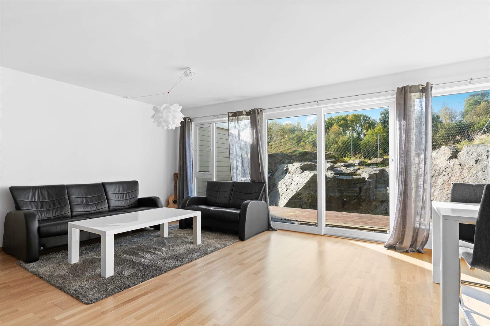 Lys og romslig stue/kjøkken med store vindusflater som slipper inn mye naturlig sollys Galleribilde