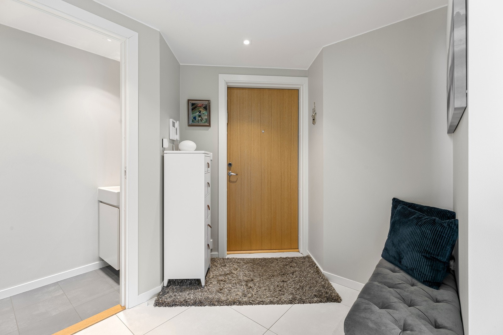 Når du kommer inn i leiligheten blir du møtt av et lyst og innbydende inngangsparti med god plass til oppbevaring av tøy i integrert skyvedørsgarderobe. Galleribilde