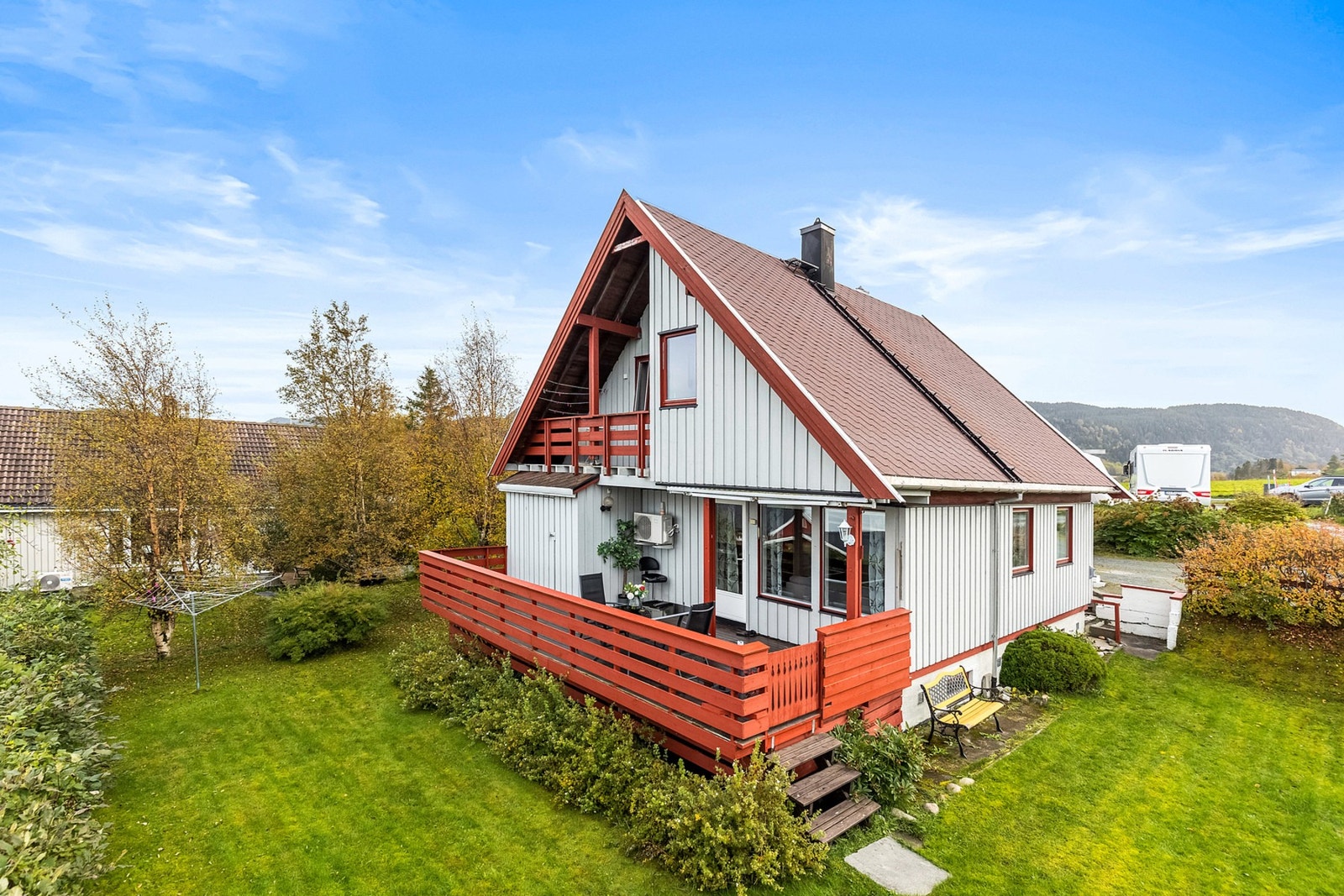 Boligen har en pent opparbeidet tomt med hage og busker. Galleribilde
