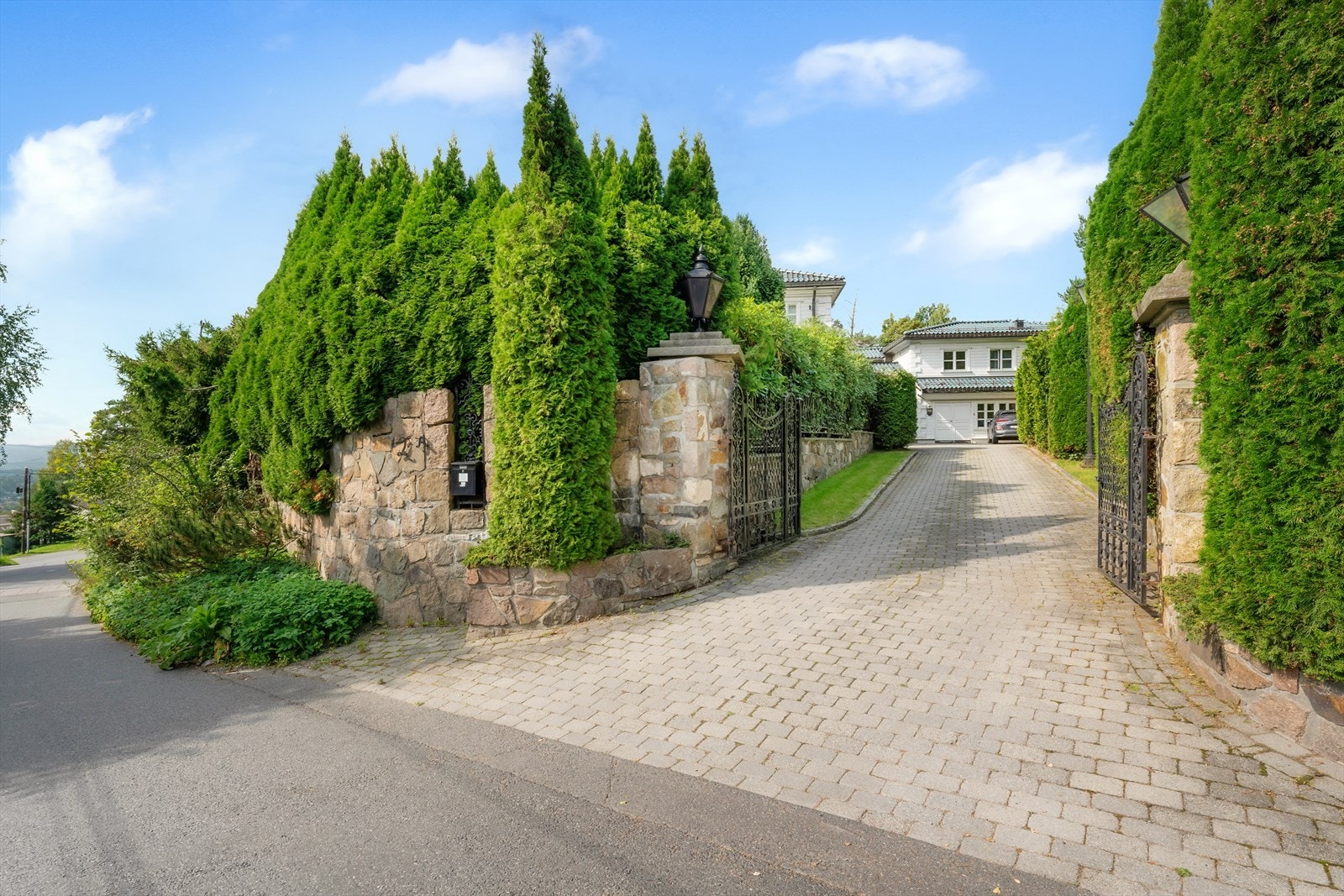 Eiendommen ligger svært skjermet til og har brosteinsbelagt innkjørsel med doble porter Galleribilde