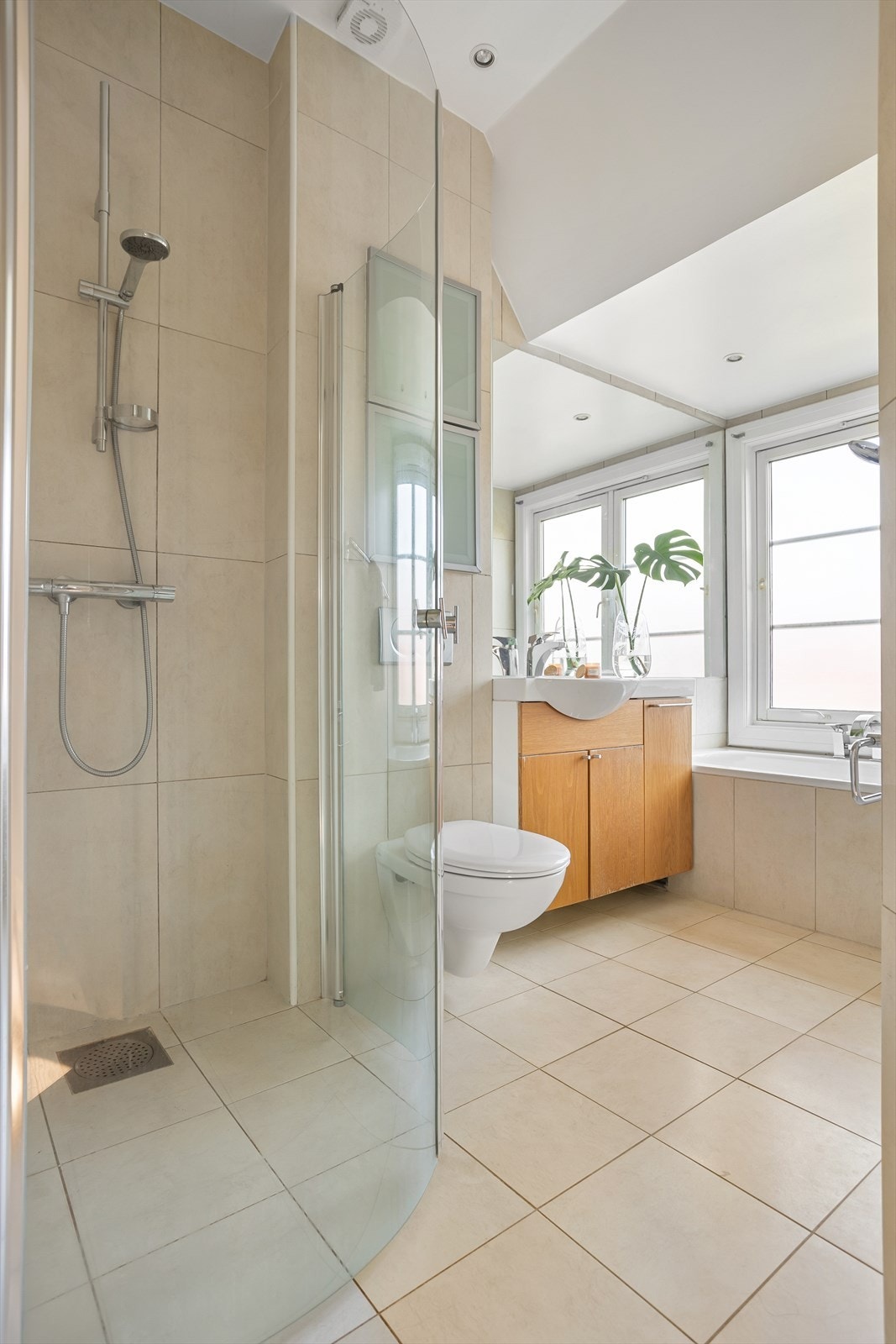 Badet er utstyrt med vegghengt wc, servant i diverse innredning, dusj i hjørne med innadslående dører og innmurt badekar. Galleribilde