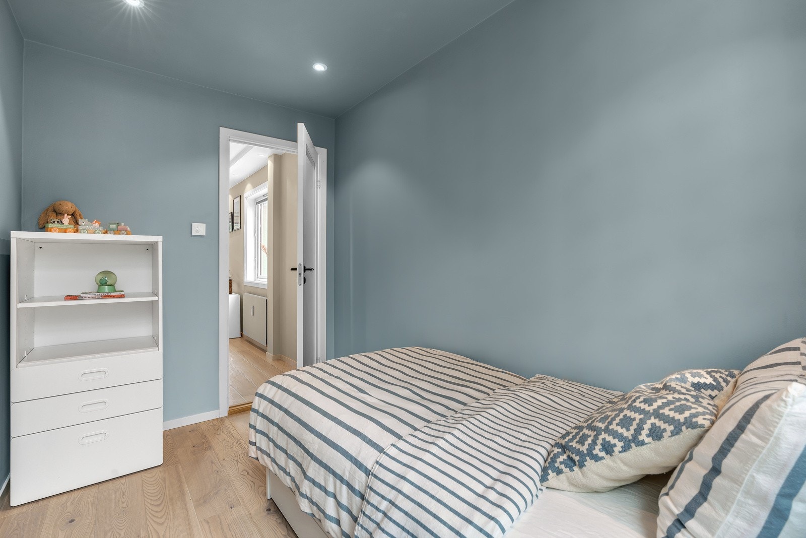 Pent oppusset soverom med nymalte overflater, downlights i himling og lyst 1-stavs eik laminatgulv. Galleribilde