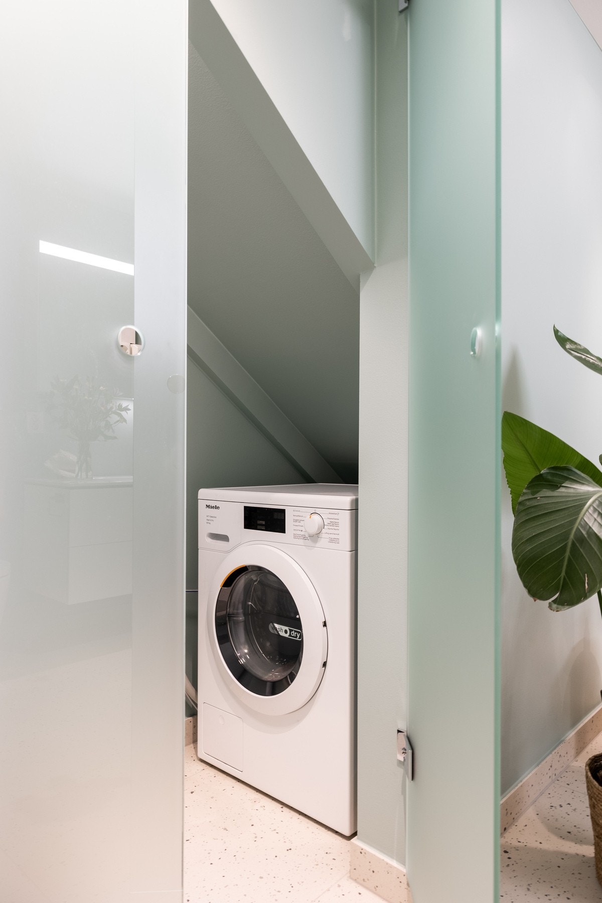 Vaskemaskin er plassert på badet, under trappen, godt skjult bak frostede dører. Galleribilde