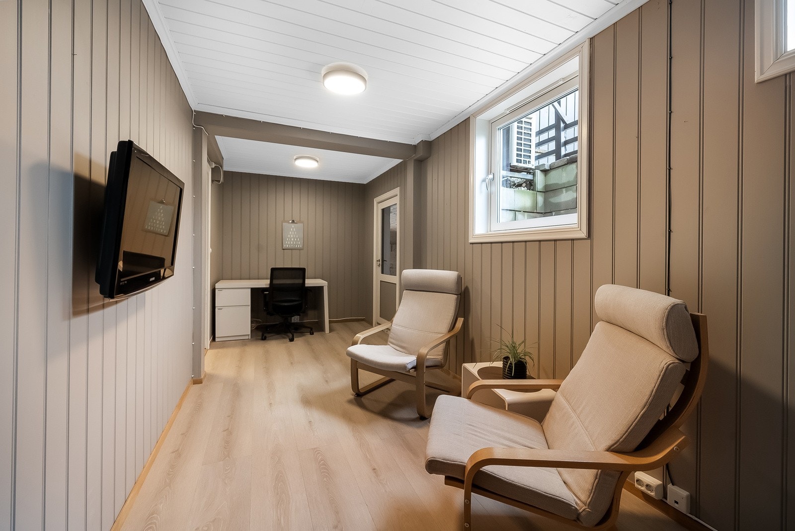 Rom i kjelleren innredet som kjellerstue med kontorplass. Galleribilde