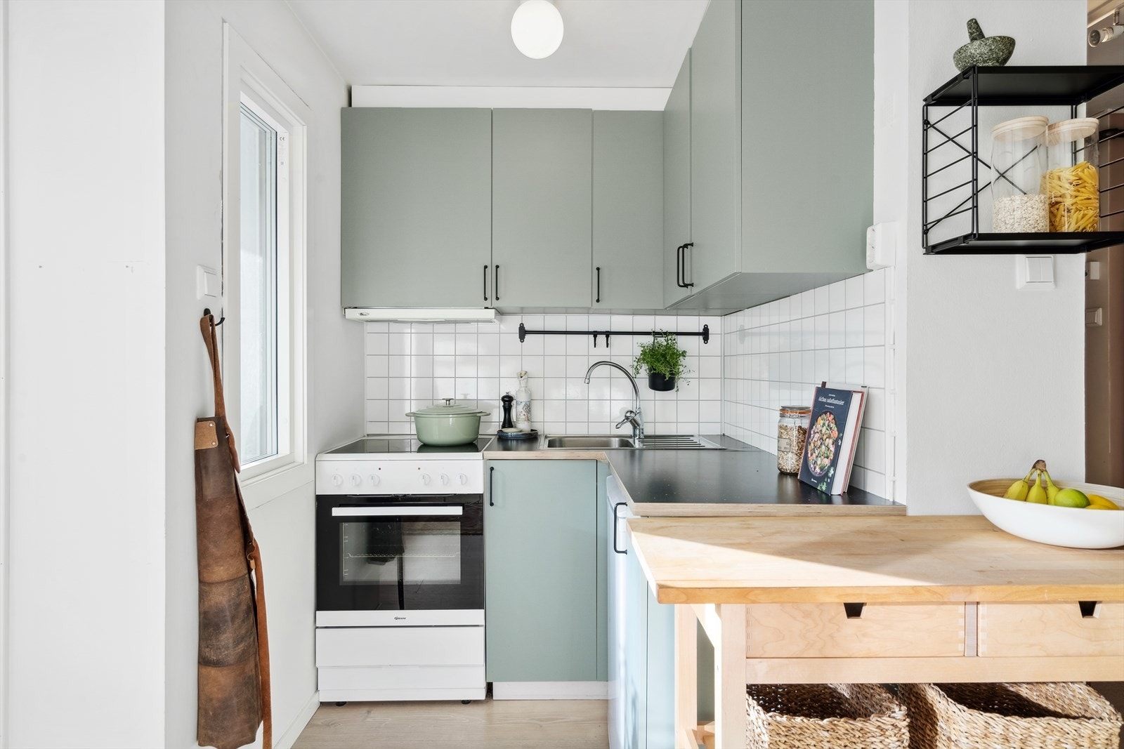 Kjøkkeninnredning av over- og underskap med laminert benkeplate og nedfelt servant. Galleribilde