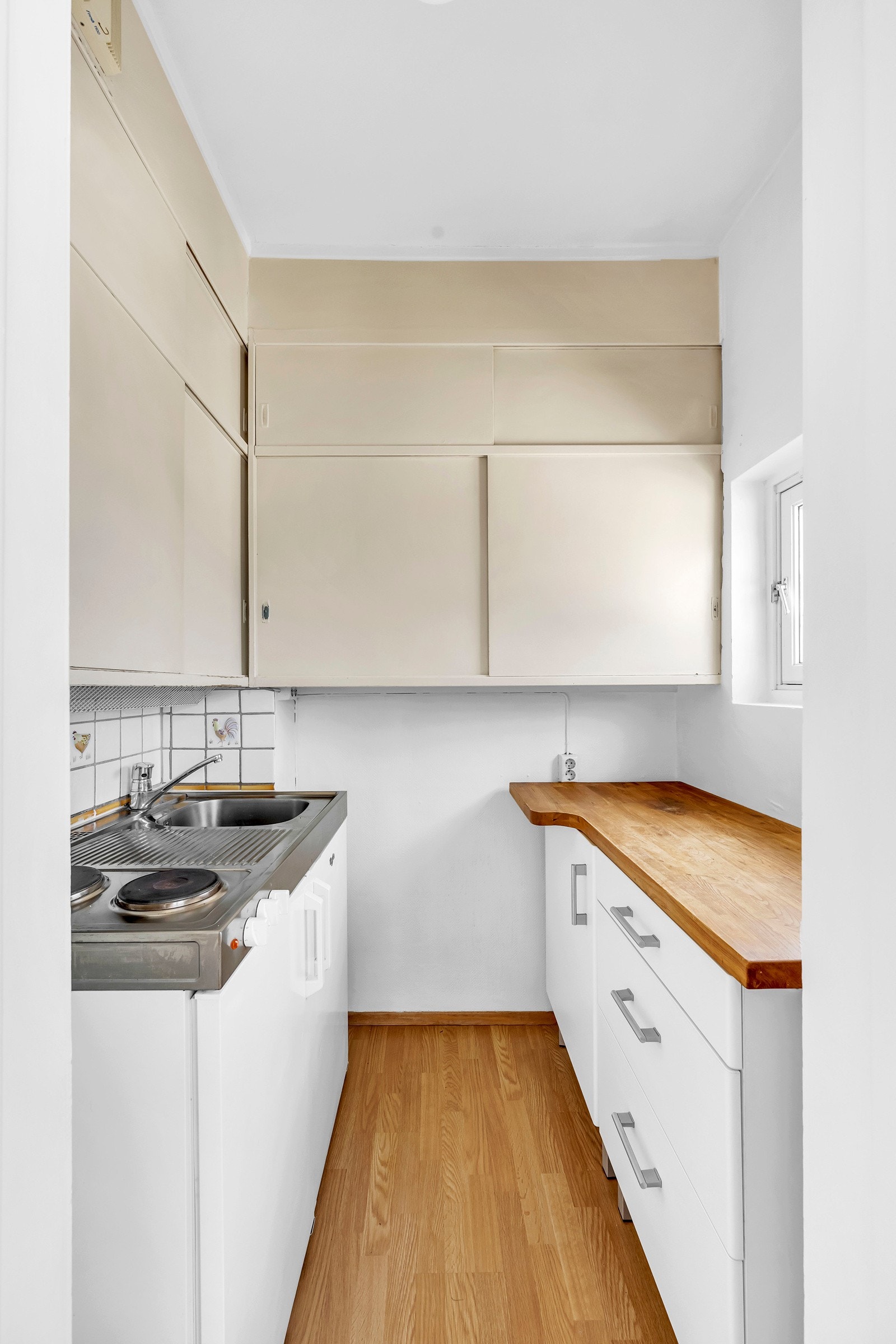 Kjøkkenet er eldre, men funksjonelt og har innredning med slette fronter og benkeplate av tre. Galleribilde