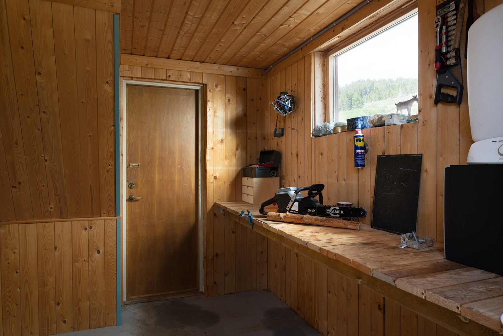 Snekkerbod med plass til oppbevaring og har innebygd benk. Galleribilde
