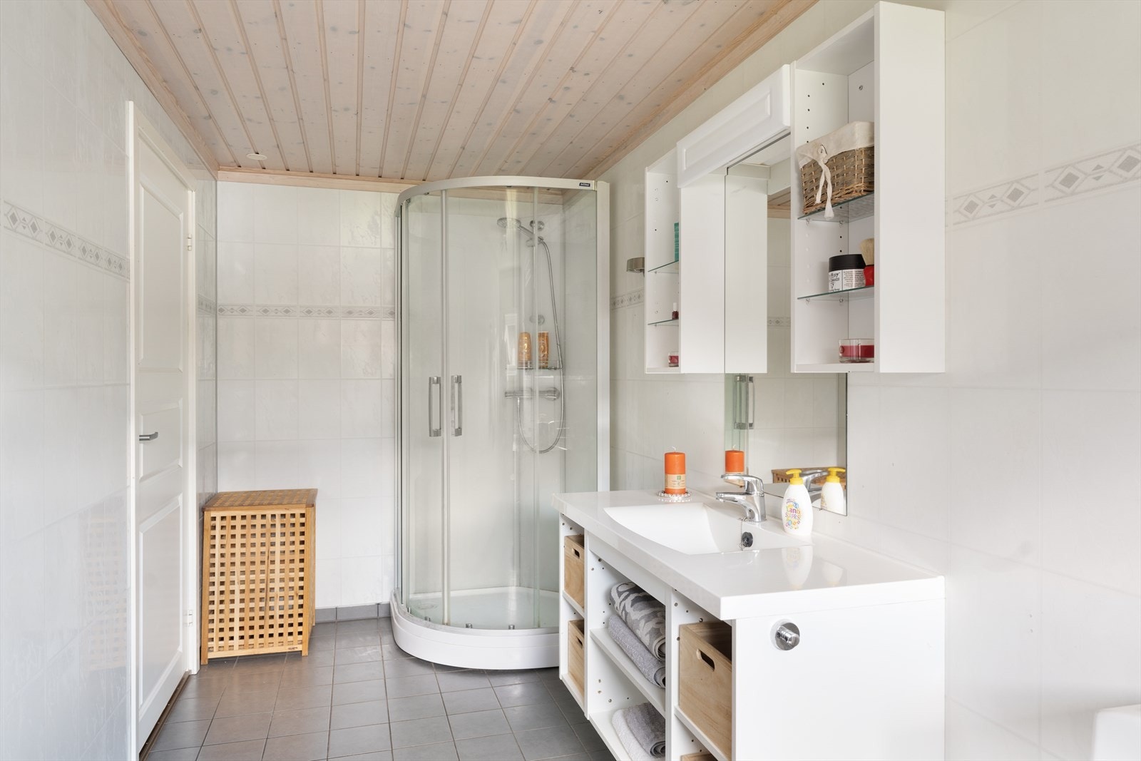 Badet er innredet med dusjkabinett, wc, servantseksjon med heldekkende servantplate, 2 overskap/hyller, samt speil med lyslist. Galleribilde