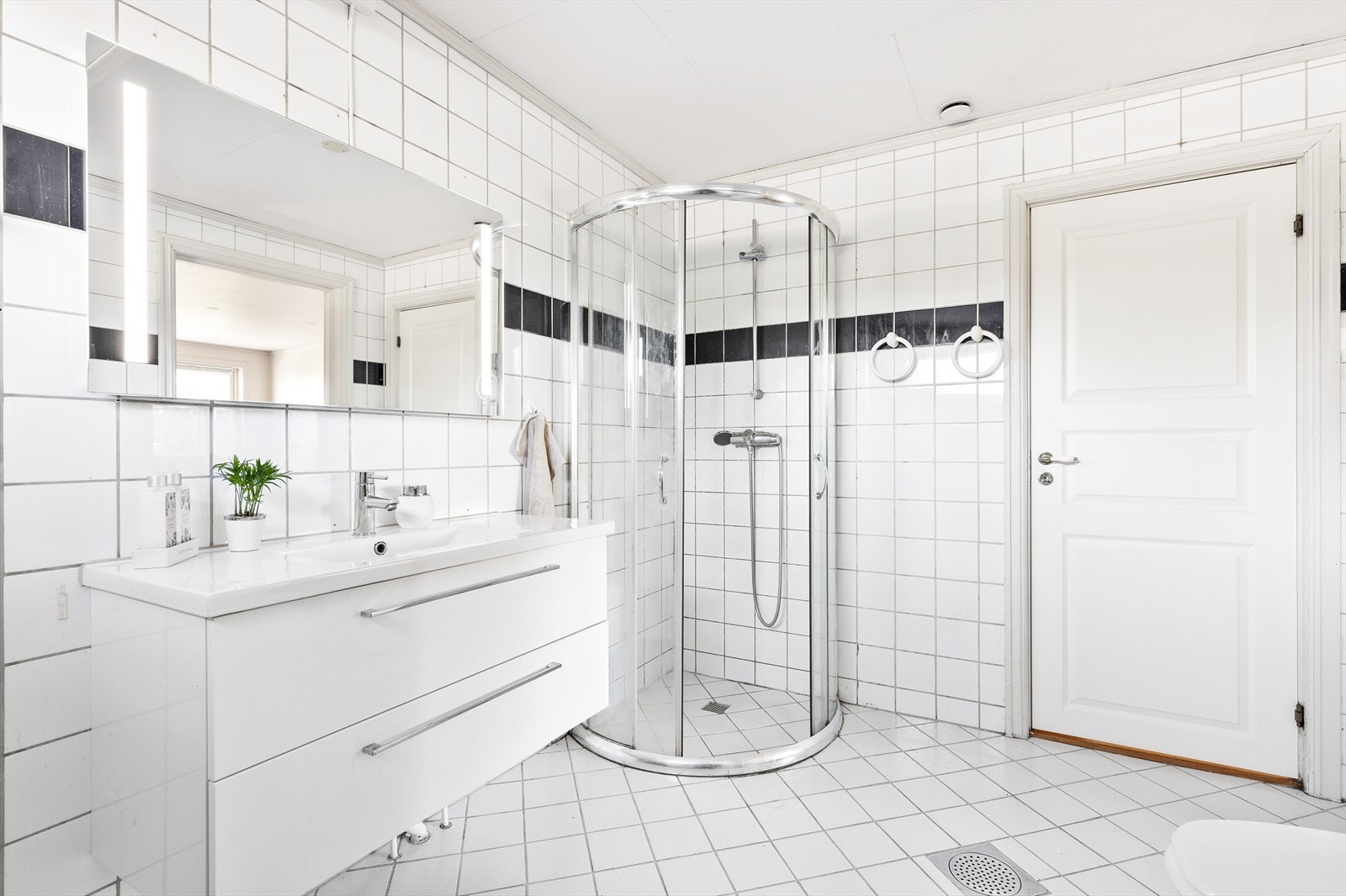 Bad i 1. etasje har wc, servant med skuffeinnredning og dusjhjørne med skyvedører. To sluk og det er røropplegg for badekar Galleribilde
