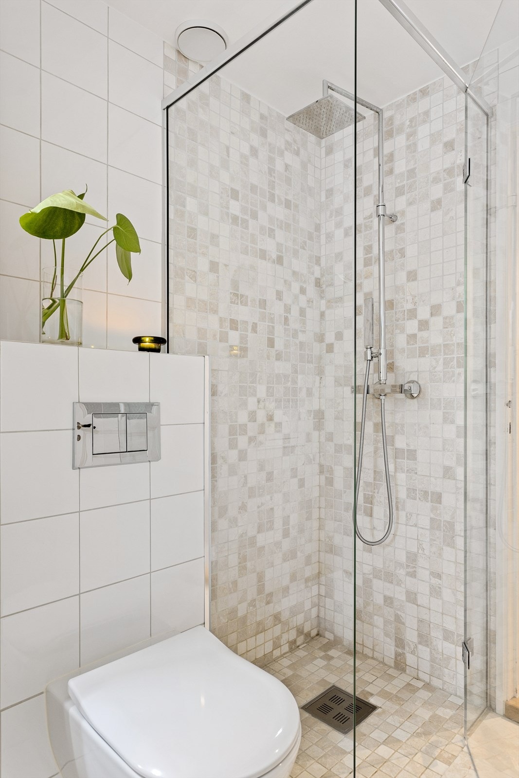 Badet er utstyrt med vegghengt wc, servant med skuffer under, dusj i hjørne med glassvegg/dør og innmurt badekar. Galleribilde
